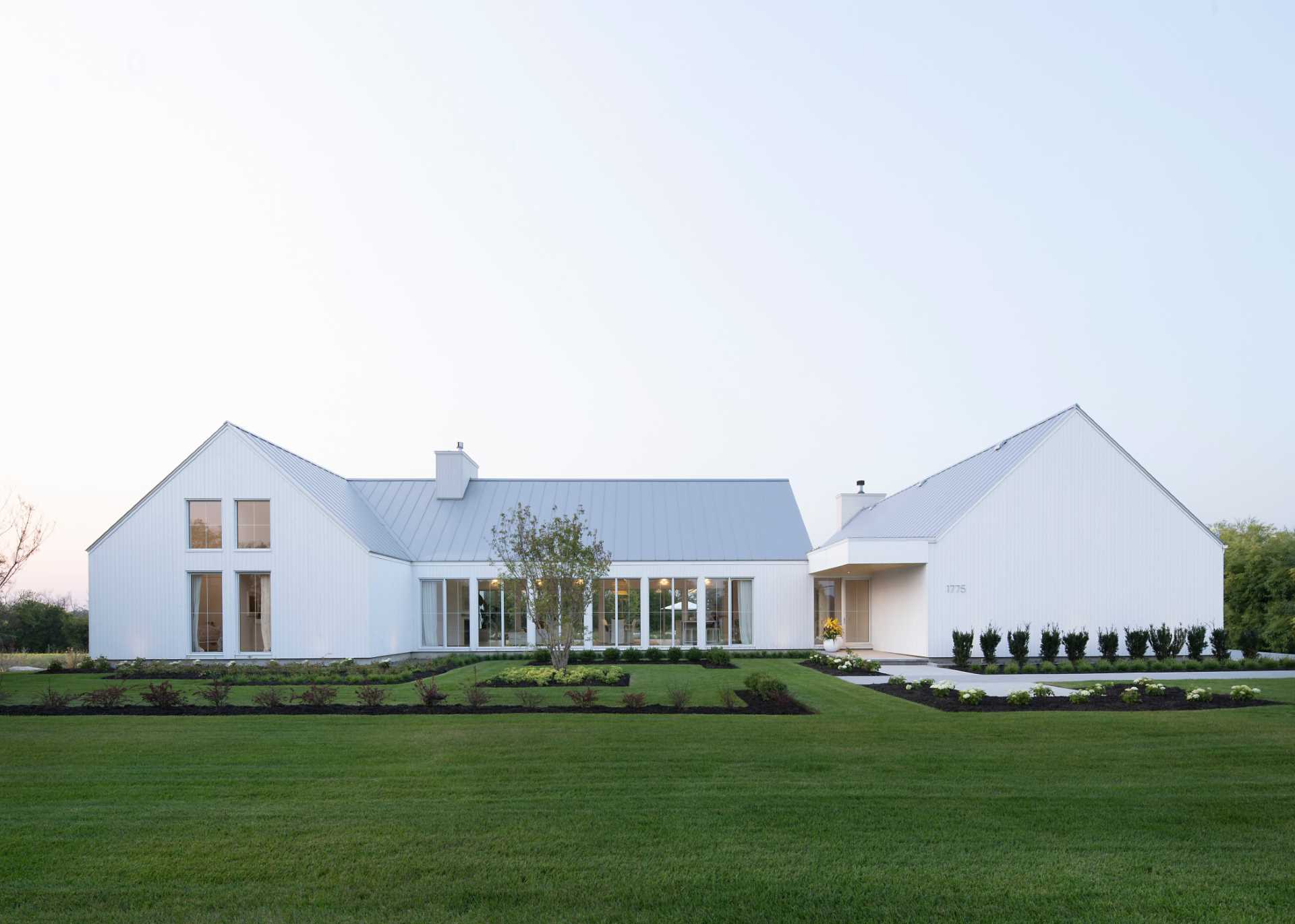 A contemporary house with a white exterior and landscaped yard.