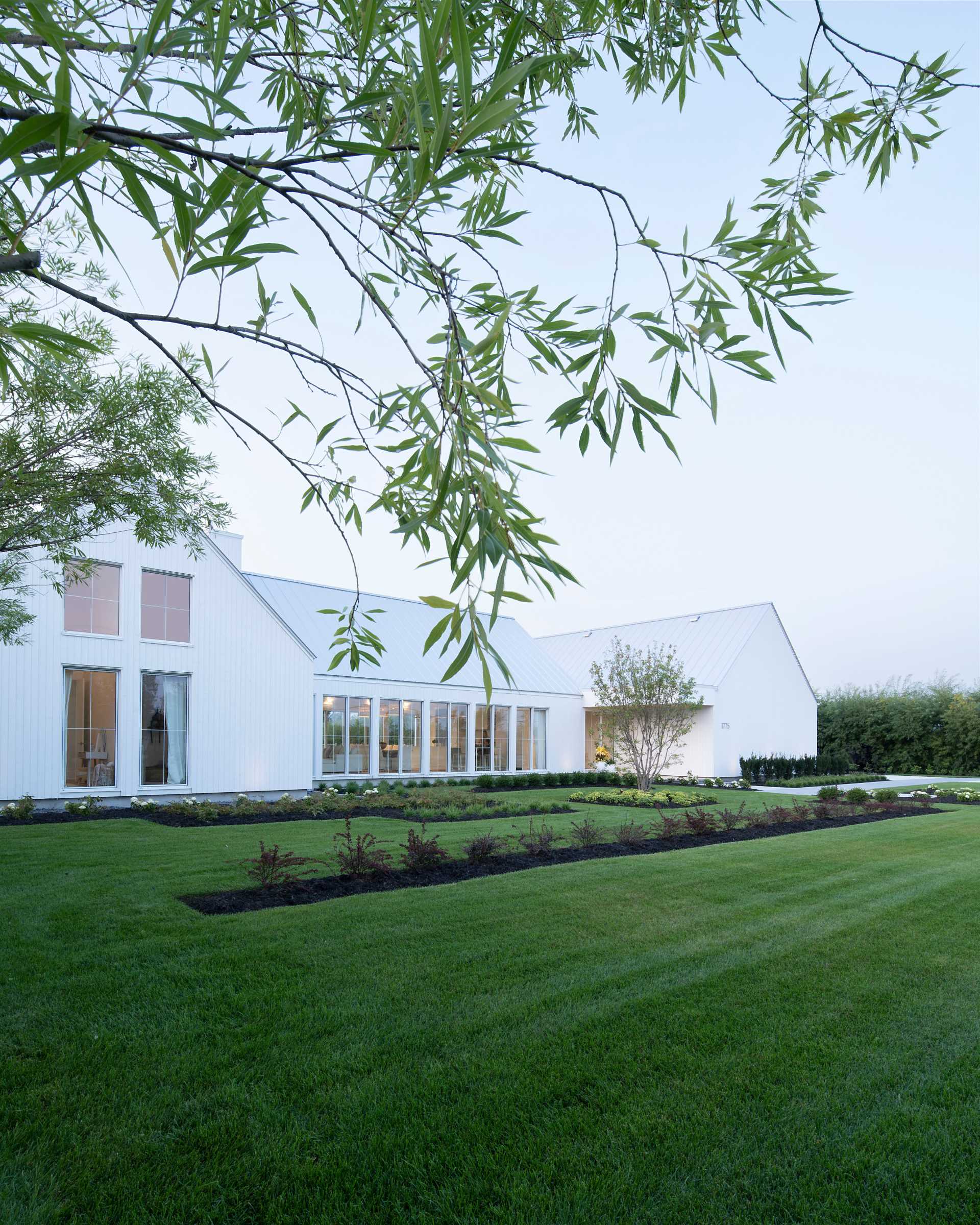A contemporary house with a white exterior and landscaped yard.