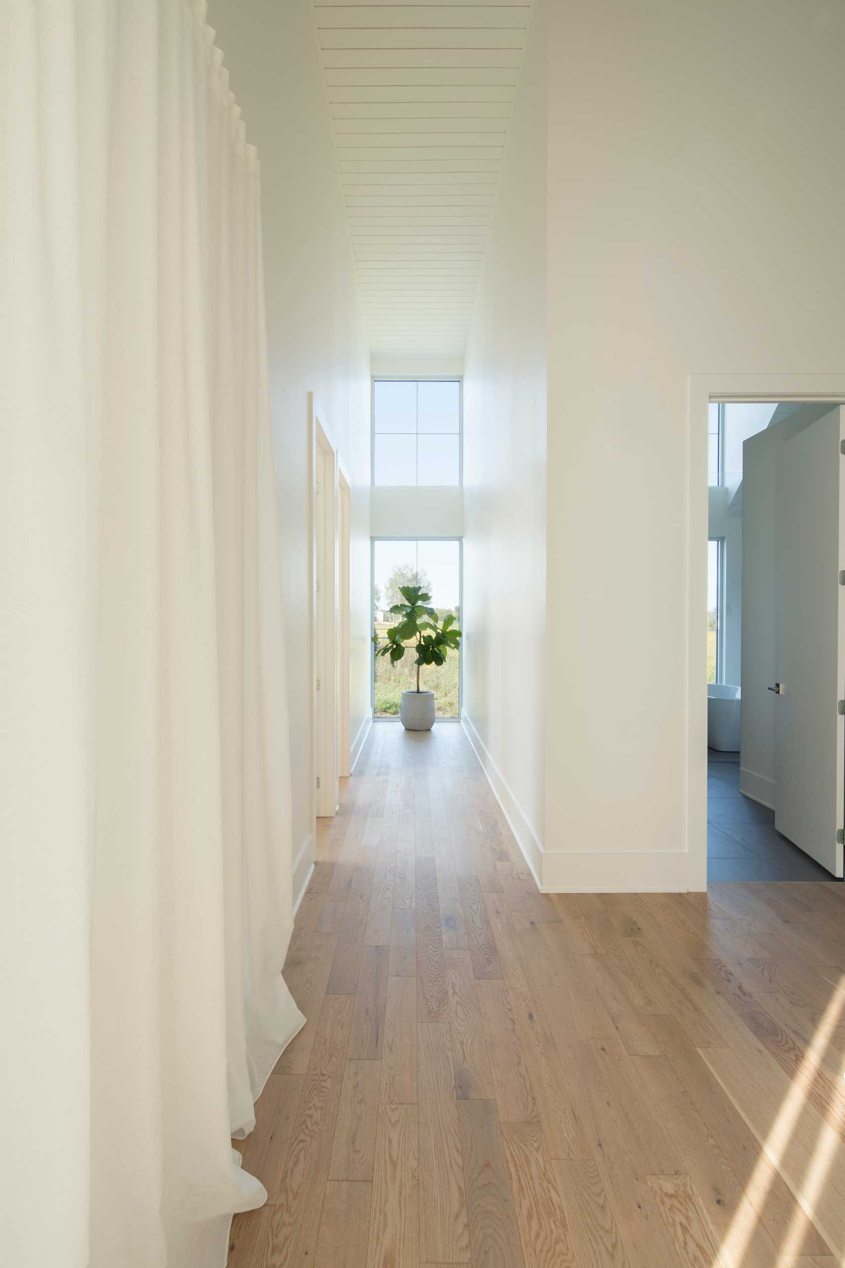 A contemporary house with a white interior and wood floors.