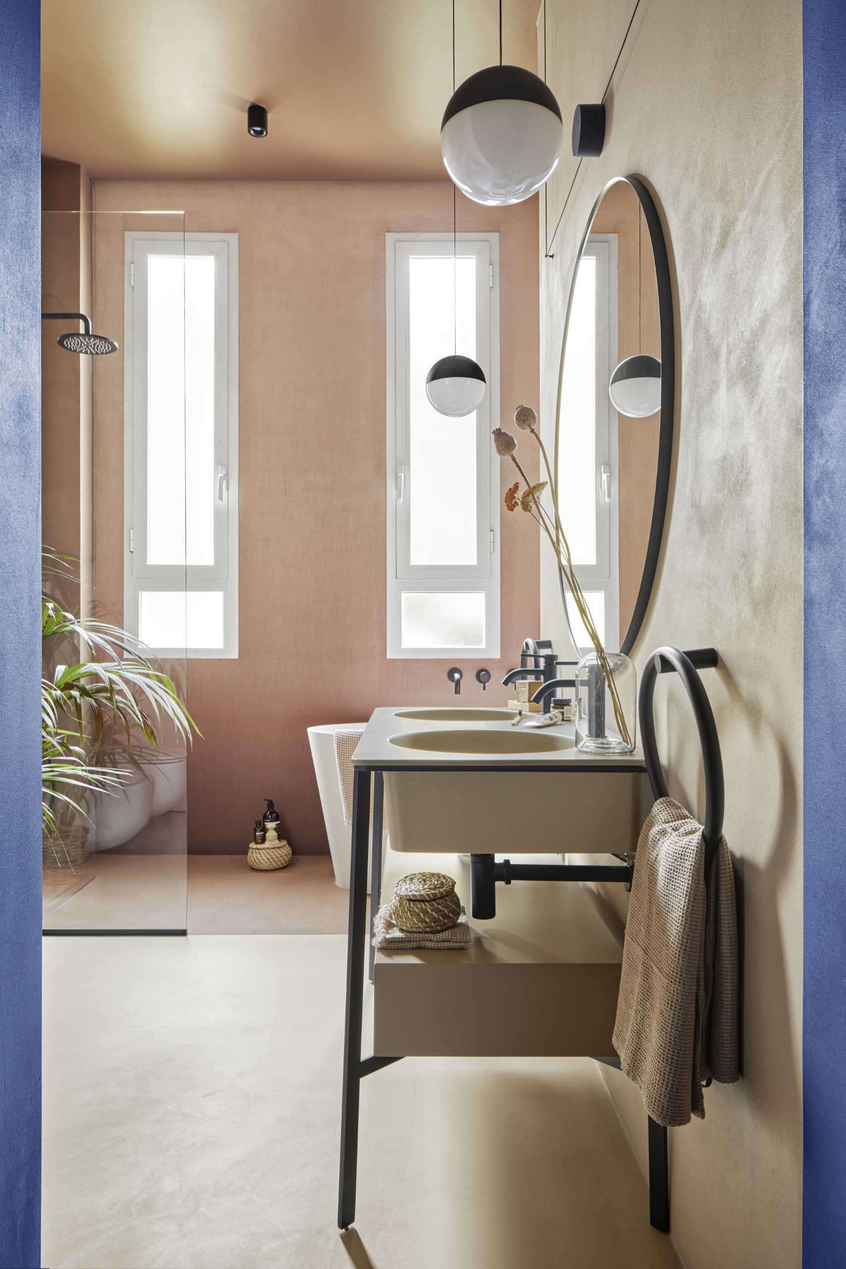 حمام مدرن با روشویی دو نفره، دوش جادار، وان حمام، و محوطه خشک‌شویی که در کمد لباس سفارشی ساخته شده است. 