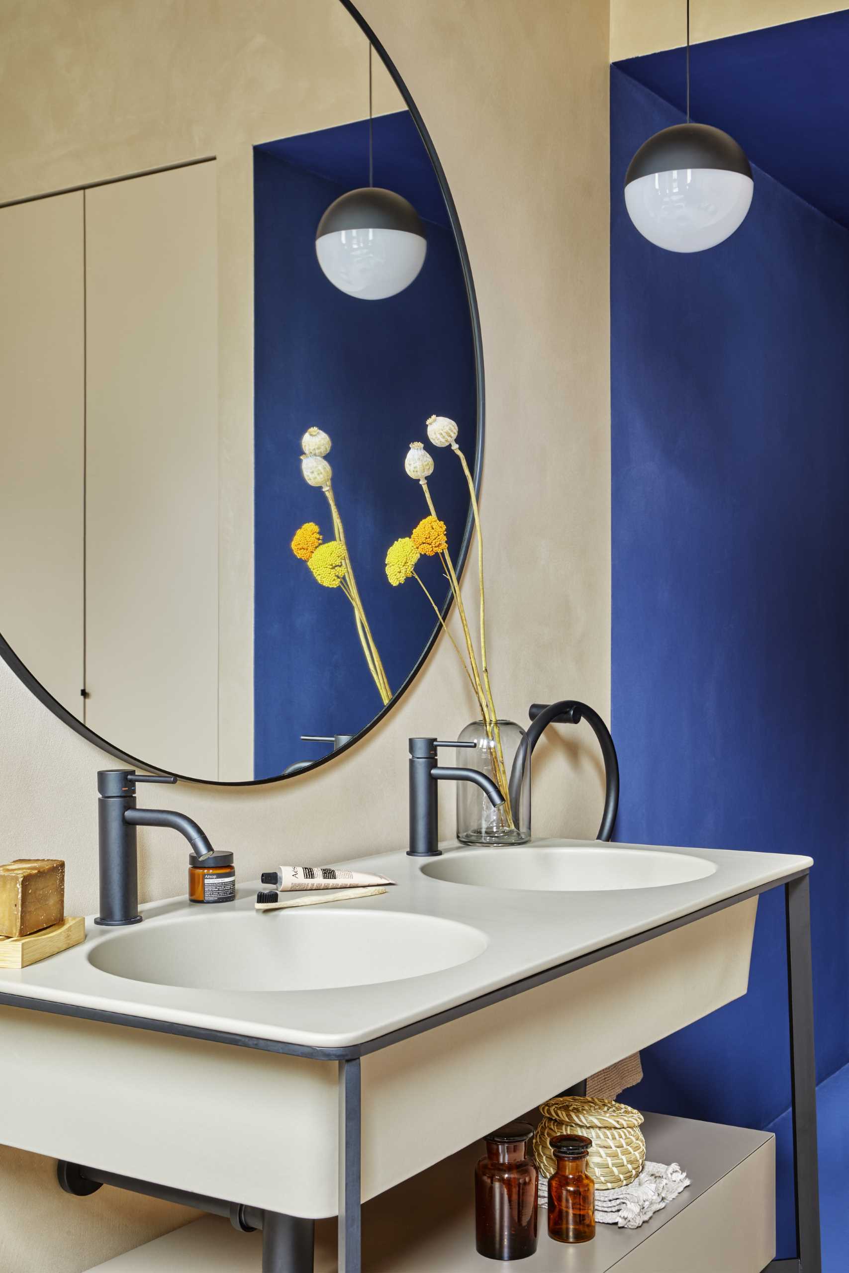 A modern bathroom with a double vanity and blue accent walls.