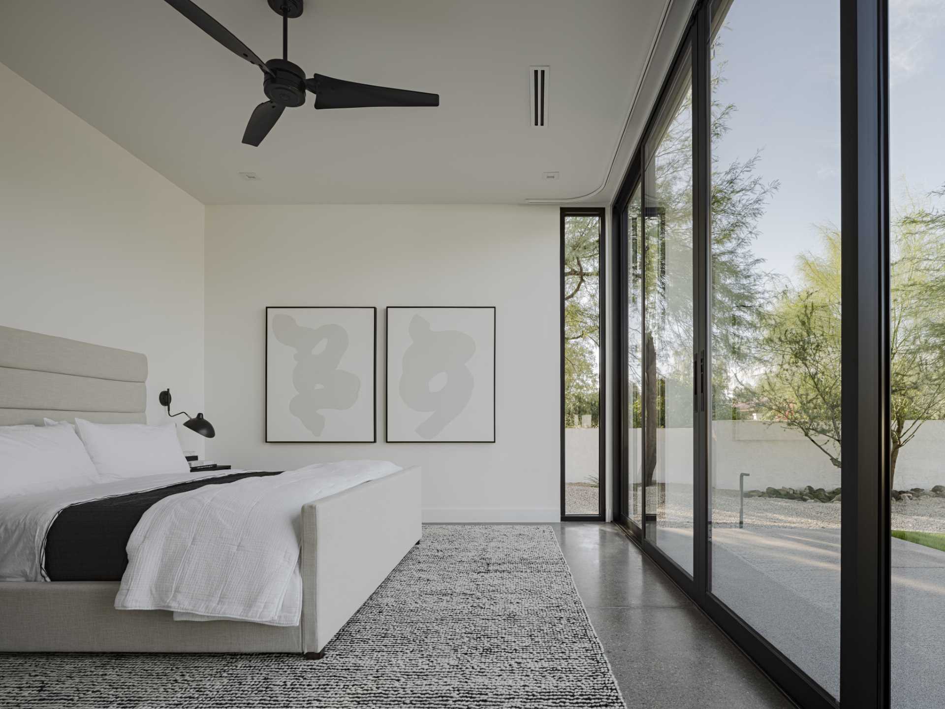 A modern bedroom with black accents that complement the black window frames.