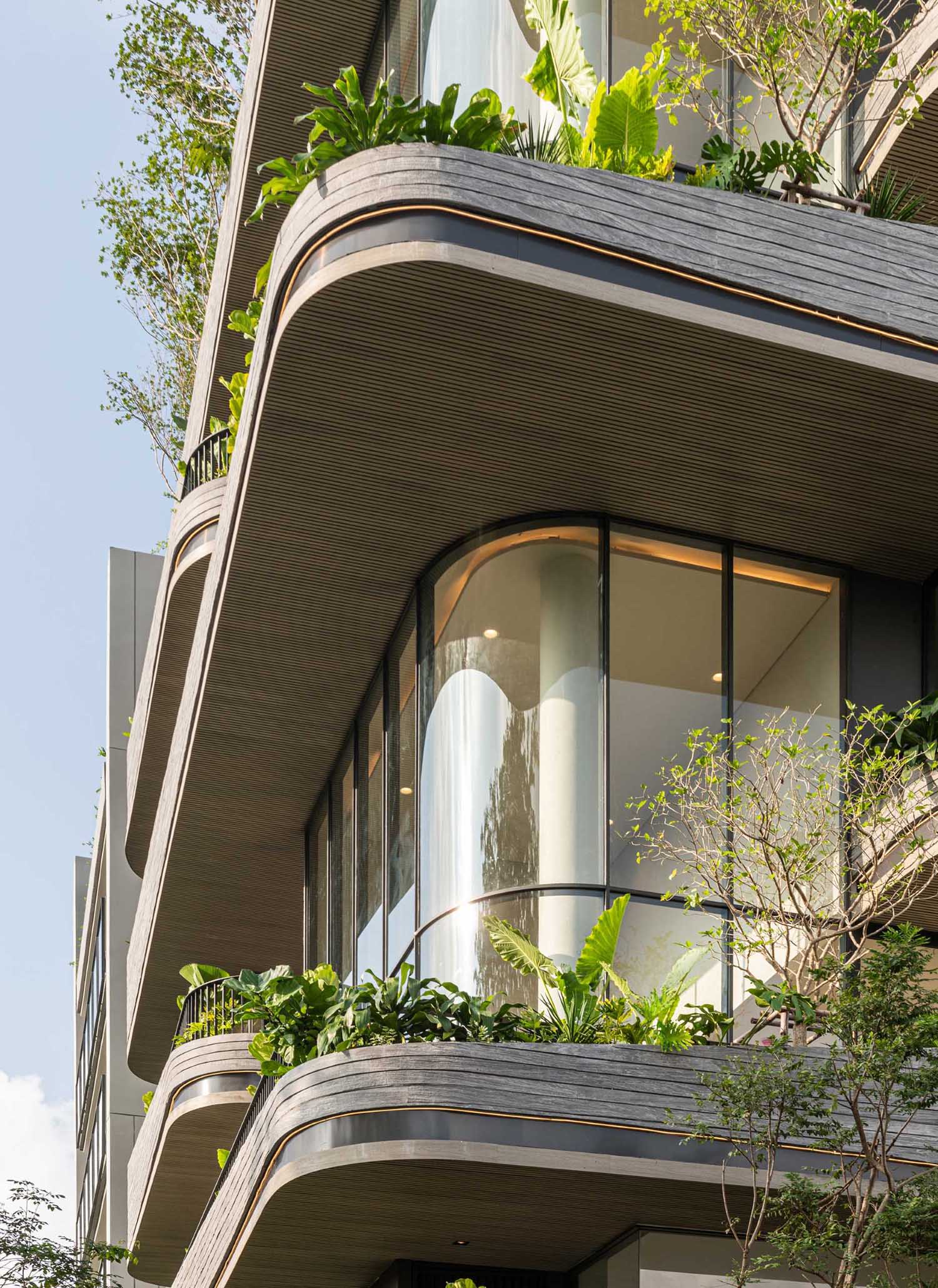 یک ساختمان کاندو مدرن از نور برای برجسته ، منحنی های بیرونی استفاده می کند.
