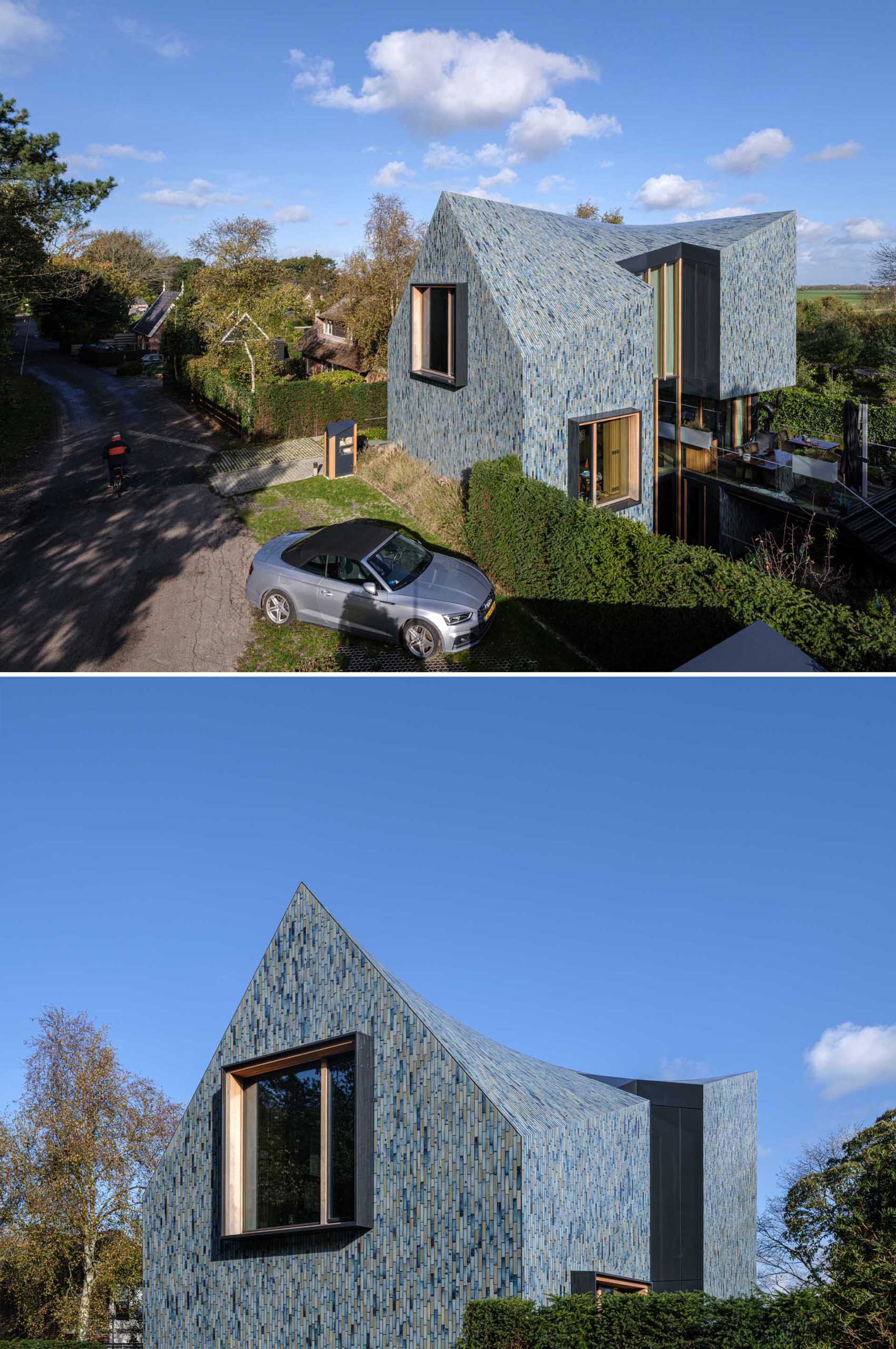 A modern house covered in blue tiles, that also has a twisted roof.