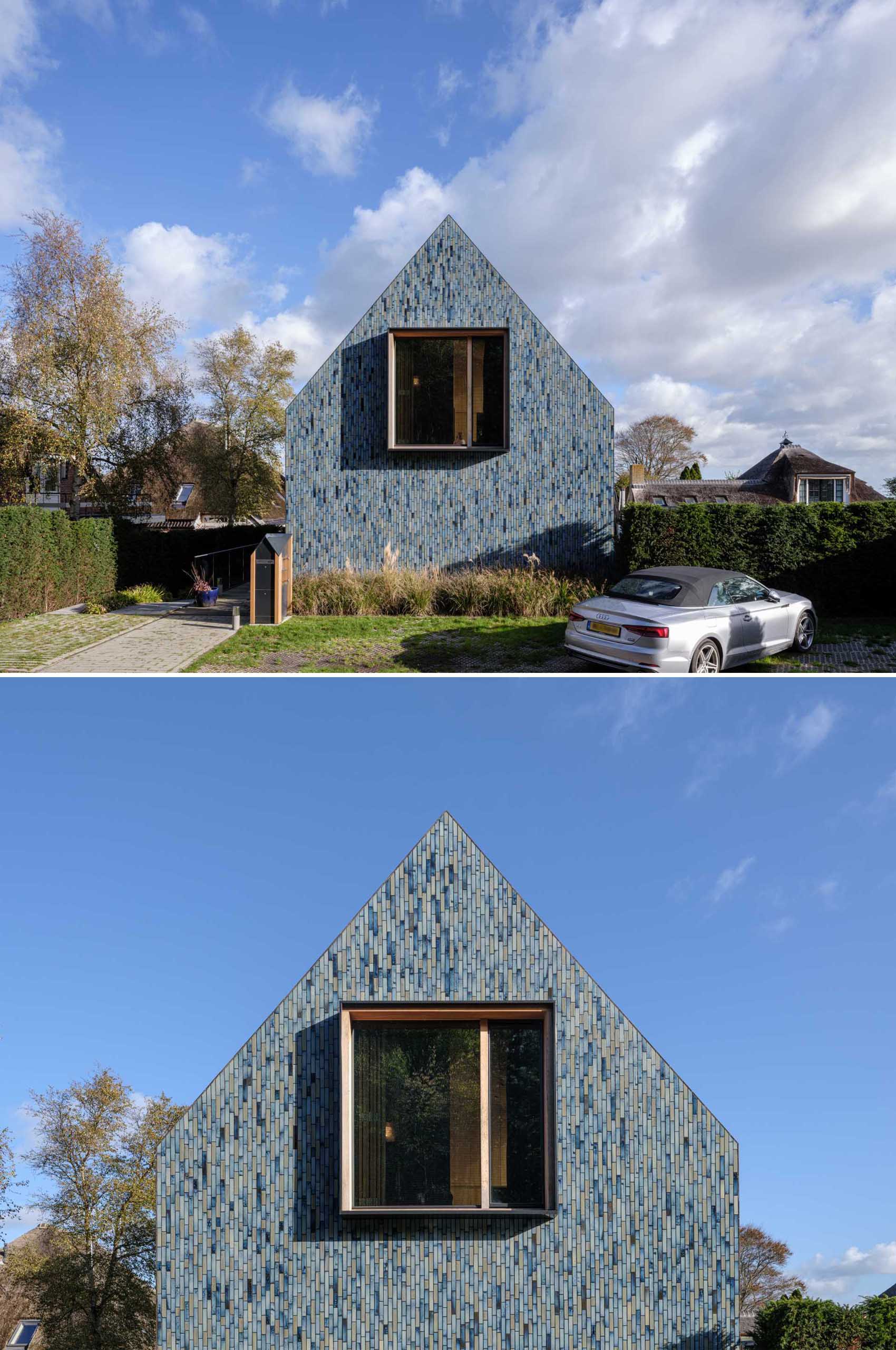 A modern house covered in blue tiles, that also has a twisted roof.