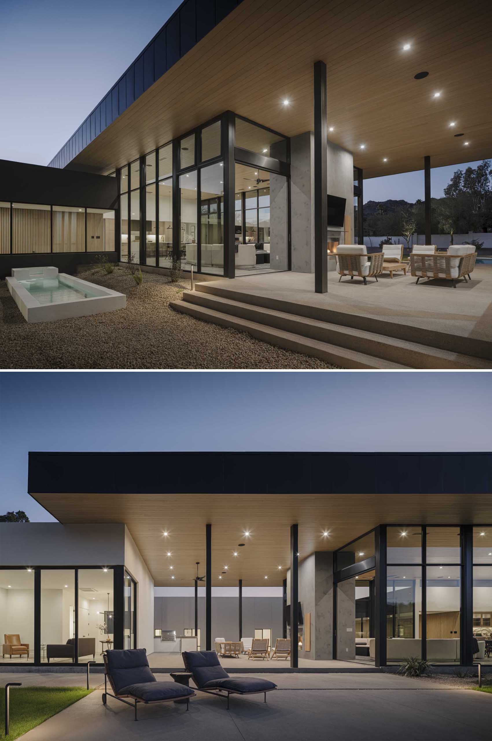 A modern house with a covered outdoor living room, fireplace, and bbq area.