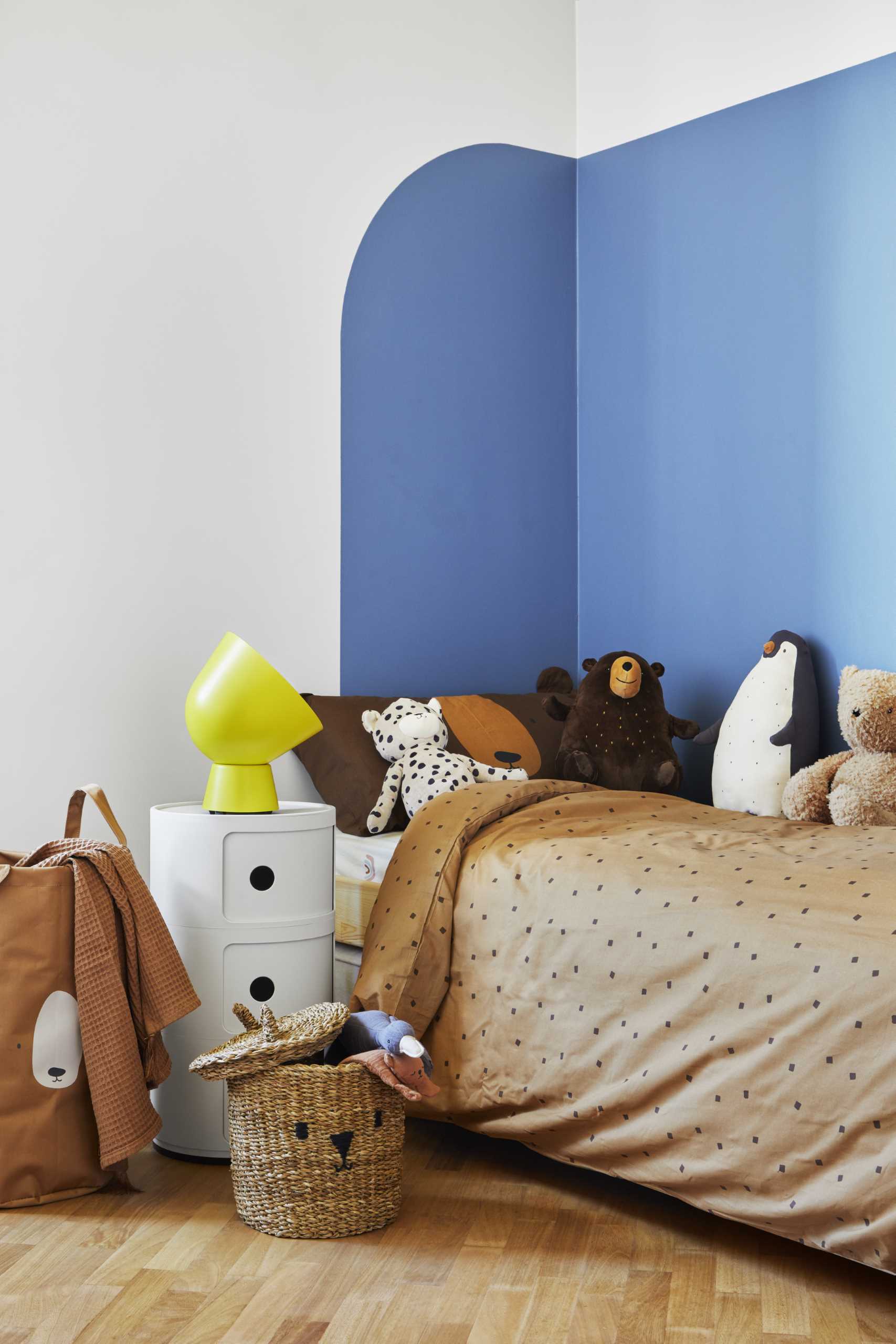 In this modern kid's bedroom, simple geometric shapes and primary colors were used. The high wainscoting in Savoy blue creates a chromatic corner, which is also used in the decorative arch of the walk-in closet. 