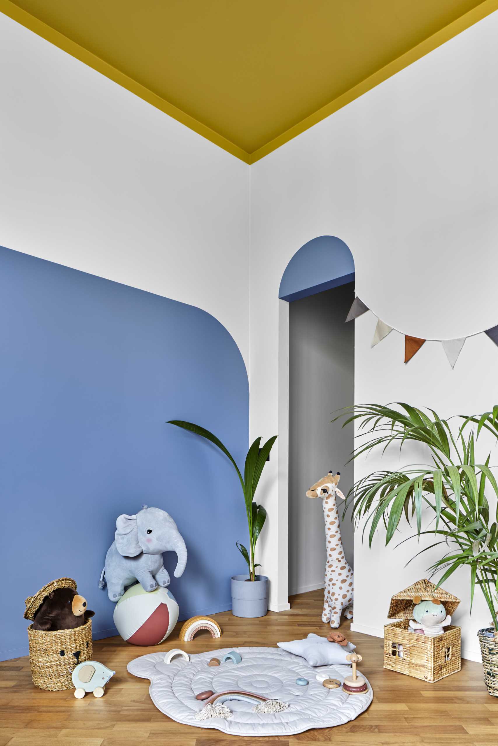 Ocher yellow descends slightly from the ceiling to the walls to convey the sense of a safe and protected area in this kid's bedroom.