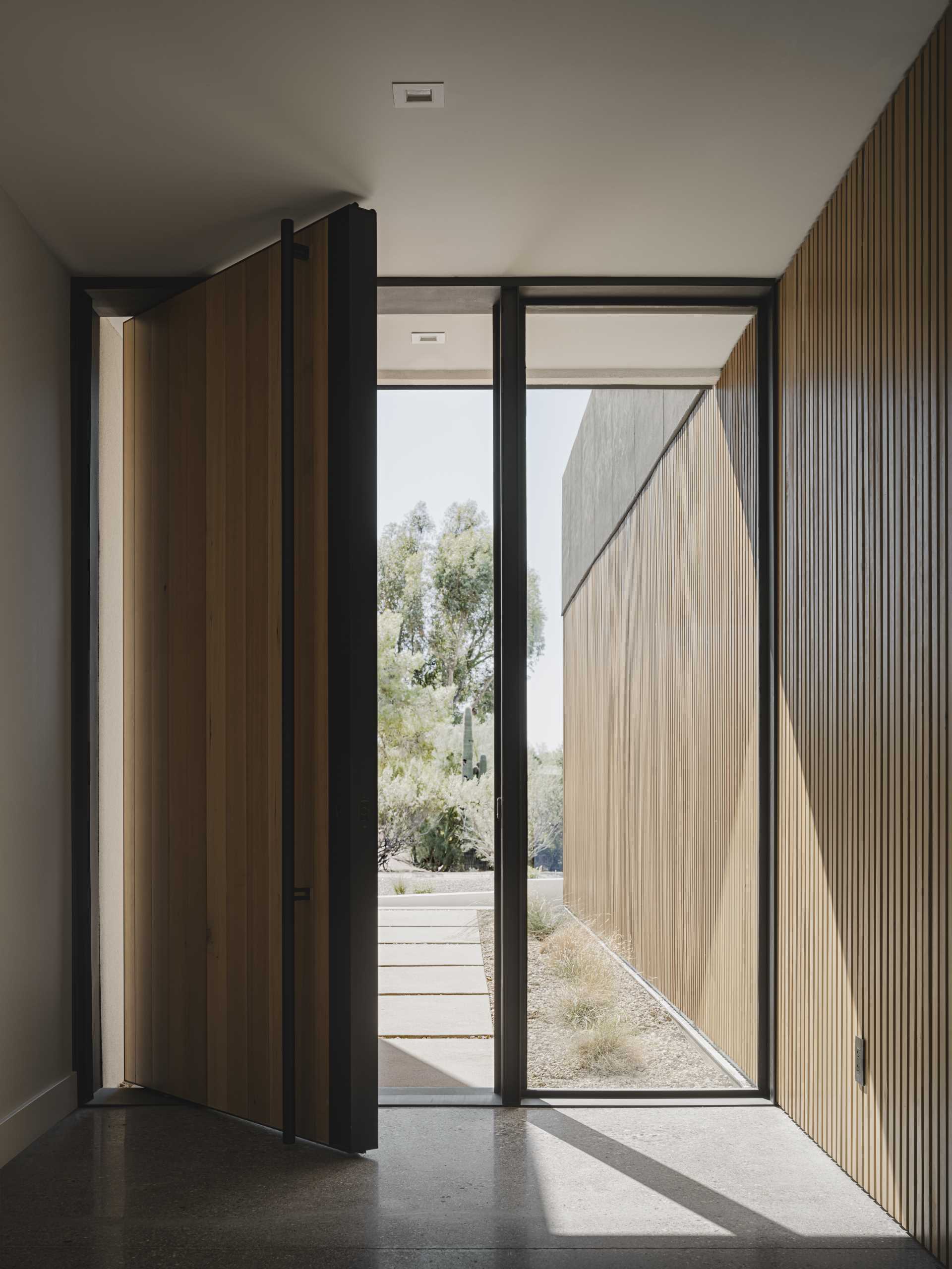 A modern home with an oversized pivoting front door.