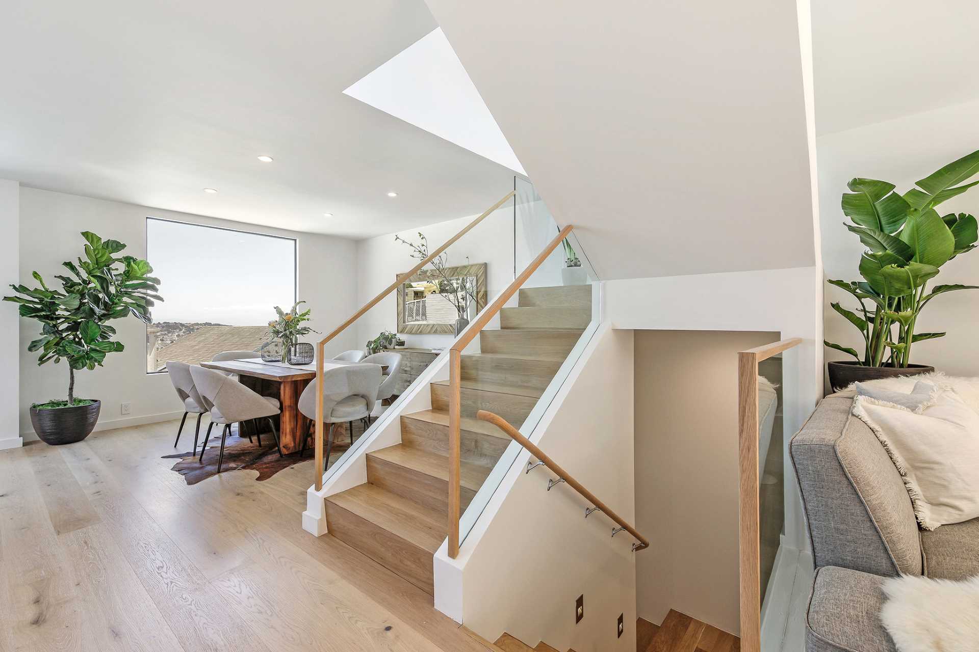 The stairs, separating the living and dining areas, connect the various levels of the home.