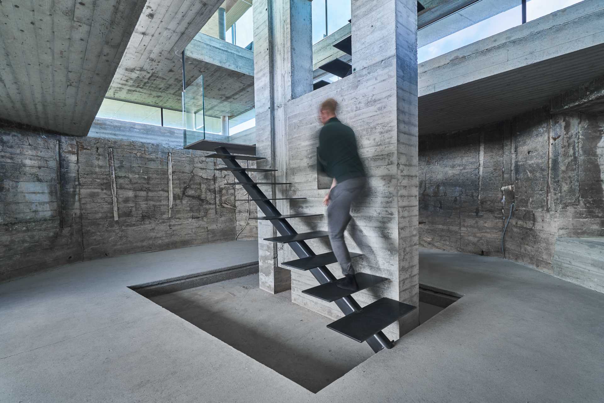 The stairs are put in as a central and sculptural element, leading from the closed parts of the bunker and up to the light of the event space.