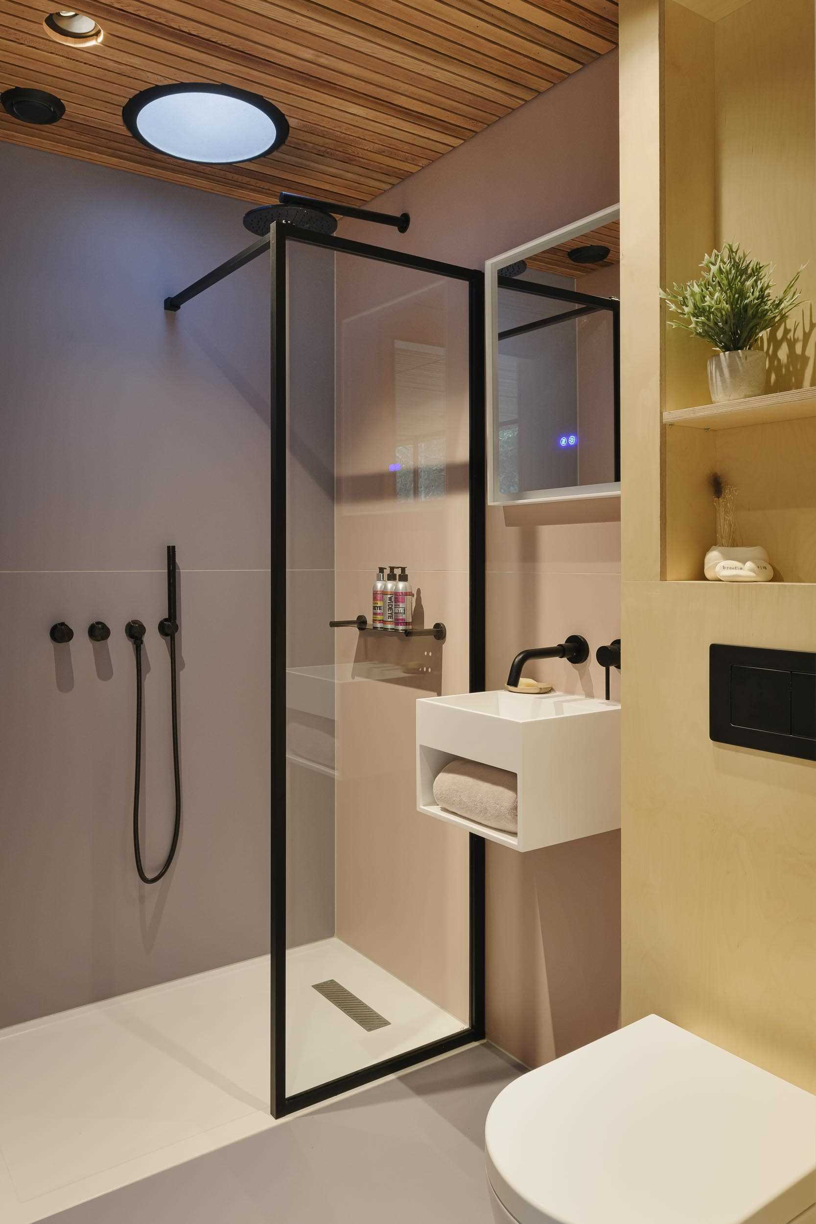 یک حمام اختصاصی کوچک با دوش دستشویی و لهجه‌های مشکی.