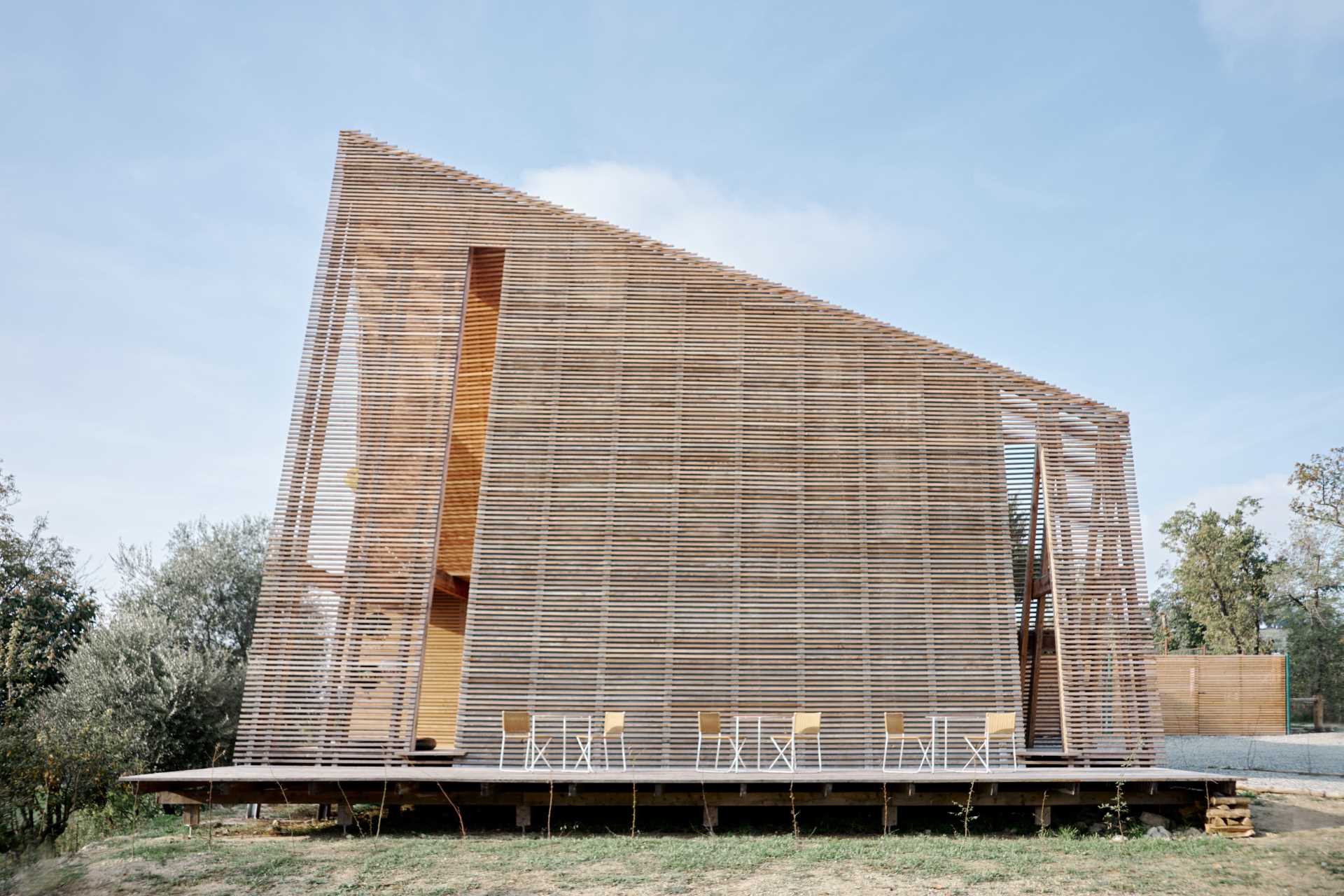 This modern A-frame cabin is raised off the ground, a construction approach that responds to the sloping land of the site.