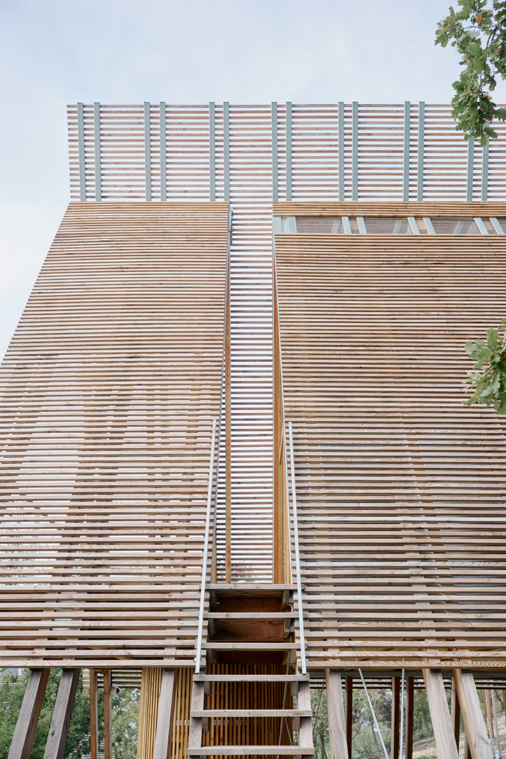 Stairs lead from the ground up to the cabin deck through a void in the exterior.