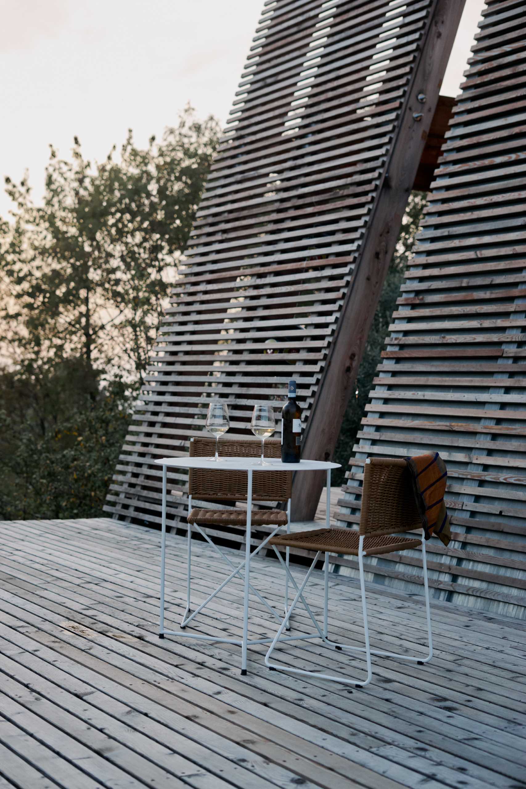 An A-frame cabin with a deck that has unobstructed views.