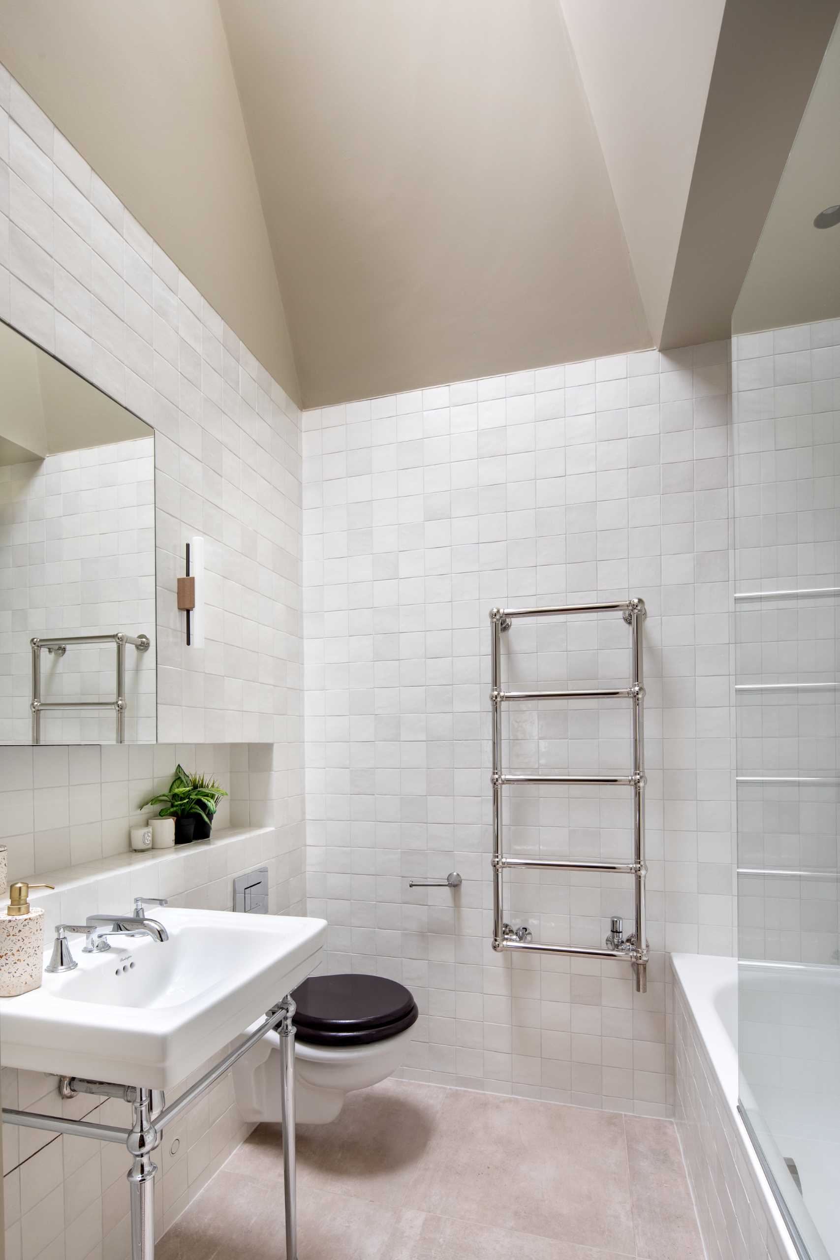 In this contemporary bathroom, square tiles cover the walls, a shelving niche adds storage, and a skylight adds natural light.
