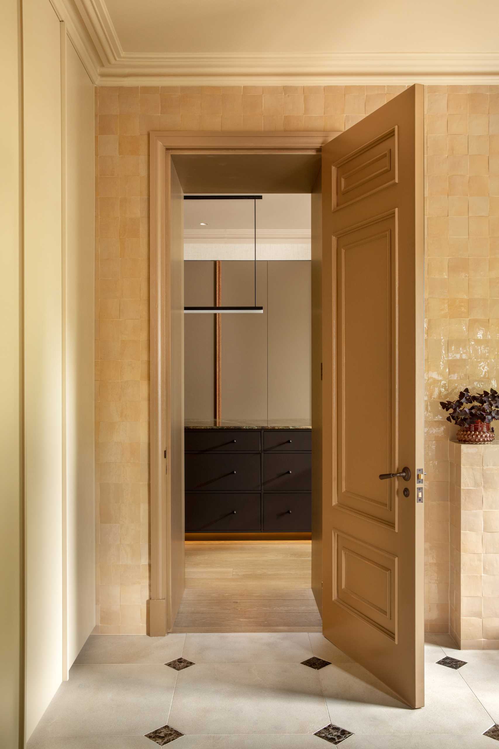 A bathroom with square tan colored tiles covering the walls.
