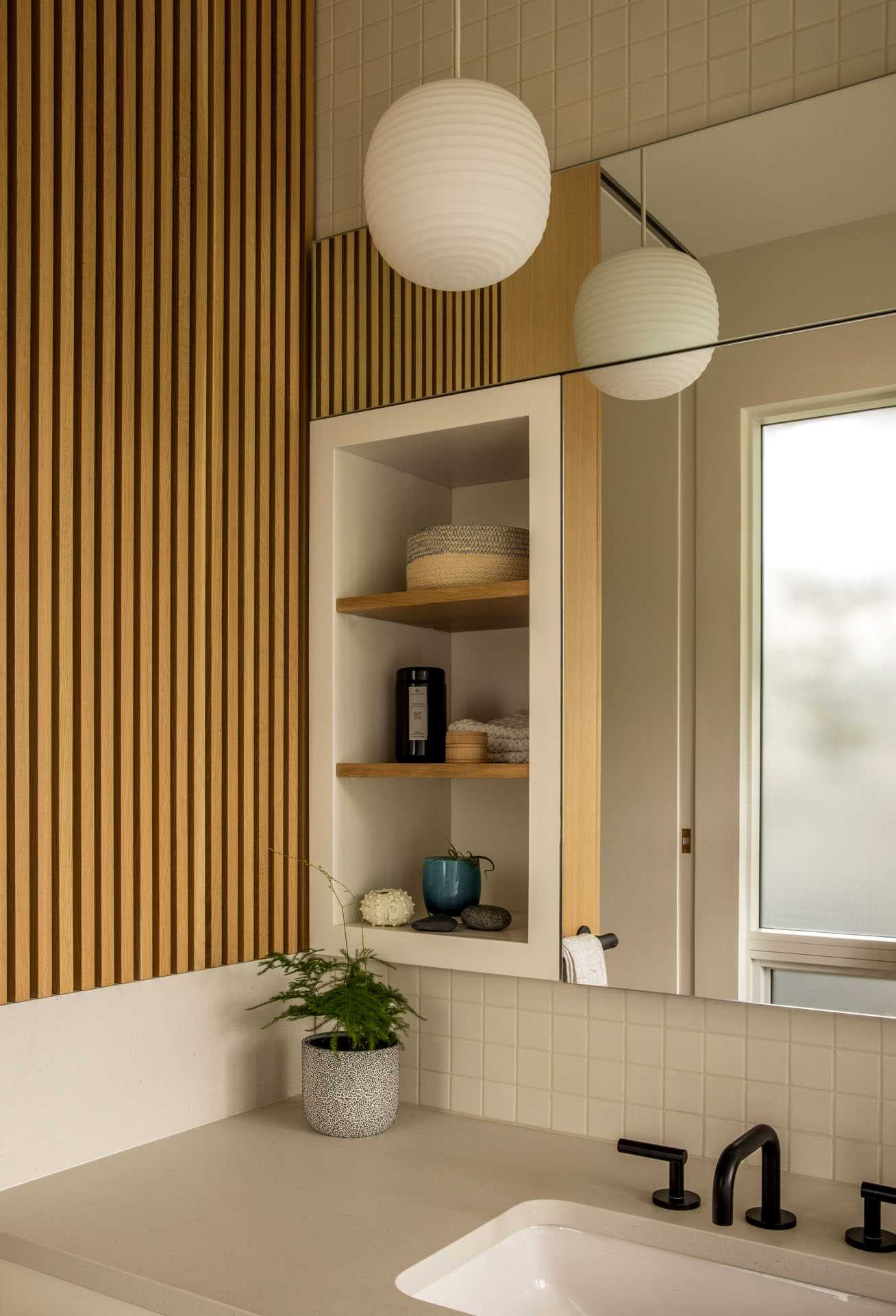 A modern family bathroom includes a traditional Japanese soaking tub (Ofuro), directly connecting to the outdoors via a folding glass door. A separate toilet room increases comfort and usability for the young family.