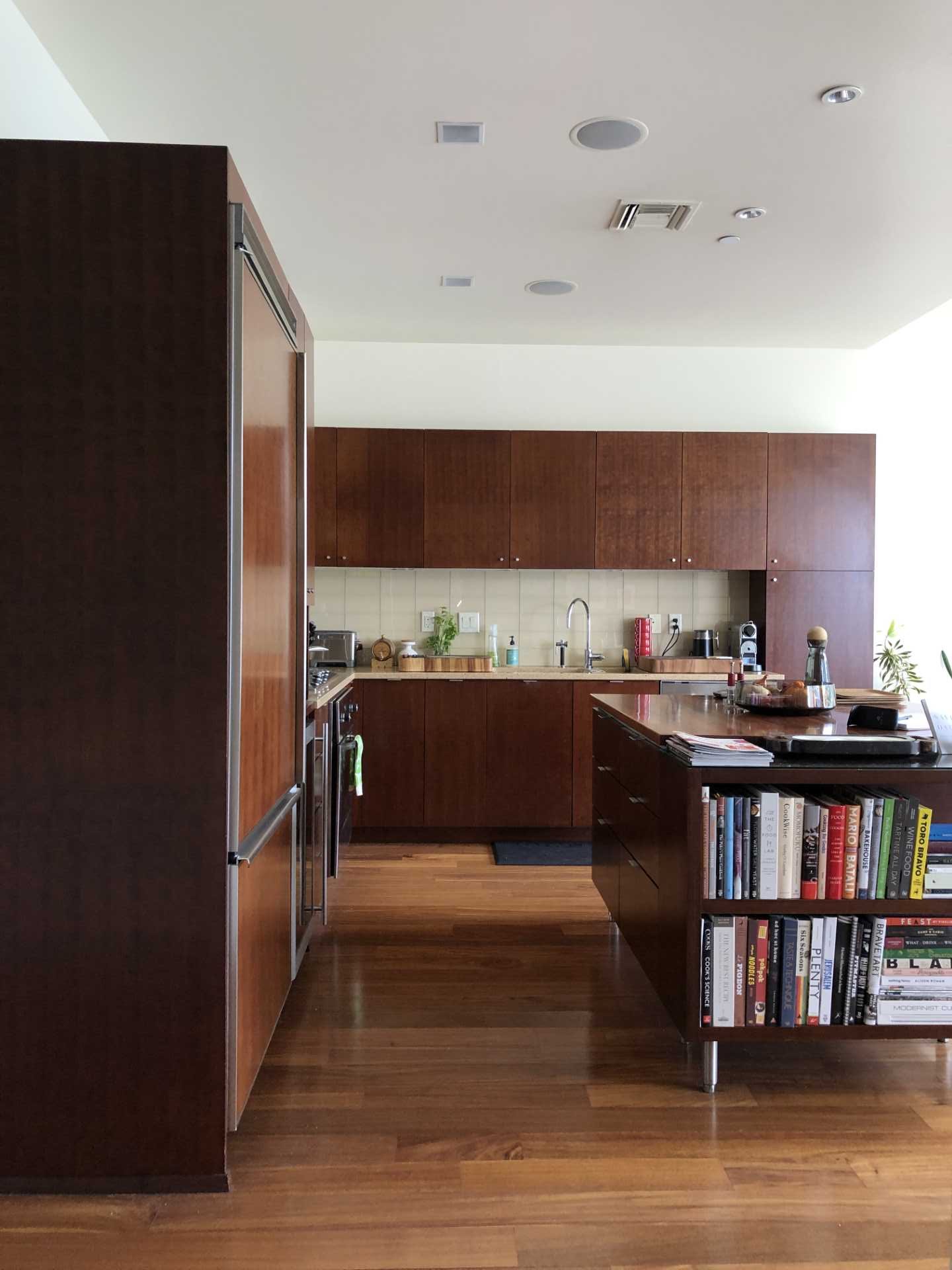 Before photo of a kitchen with dark wood cabinets.