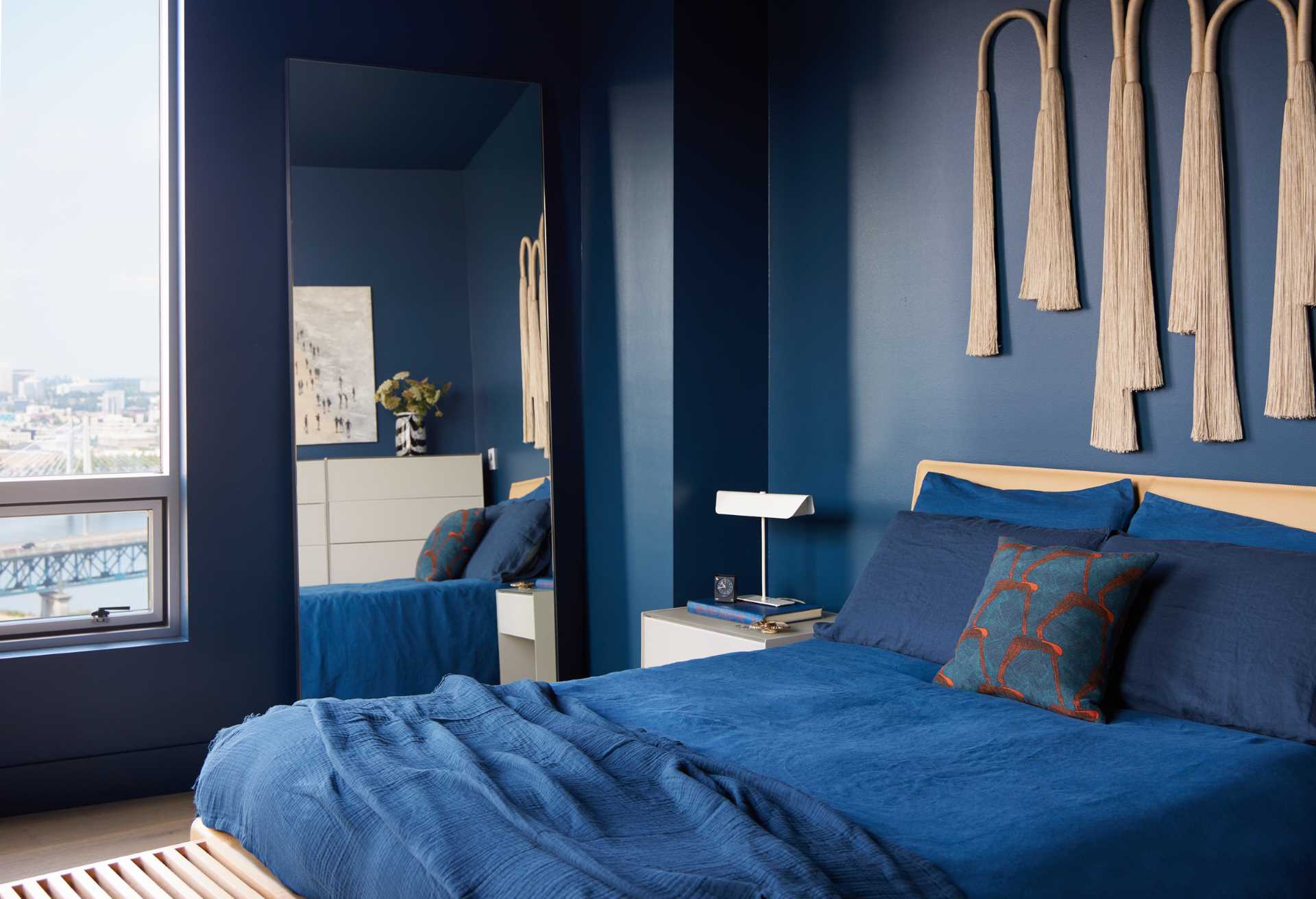 A modern bedroom with a rich blue color palette.