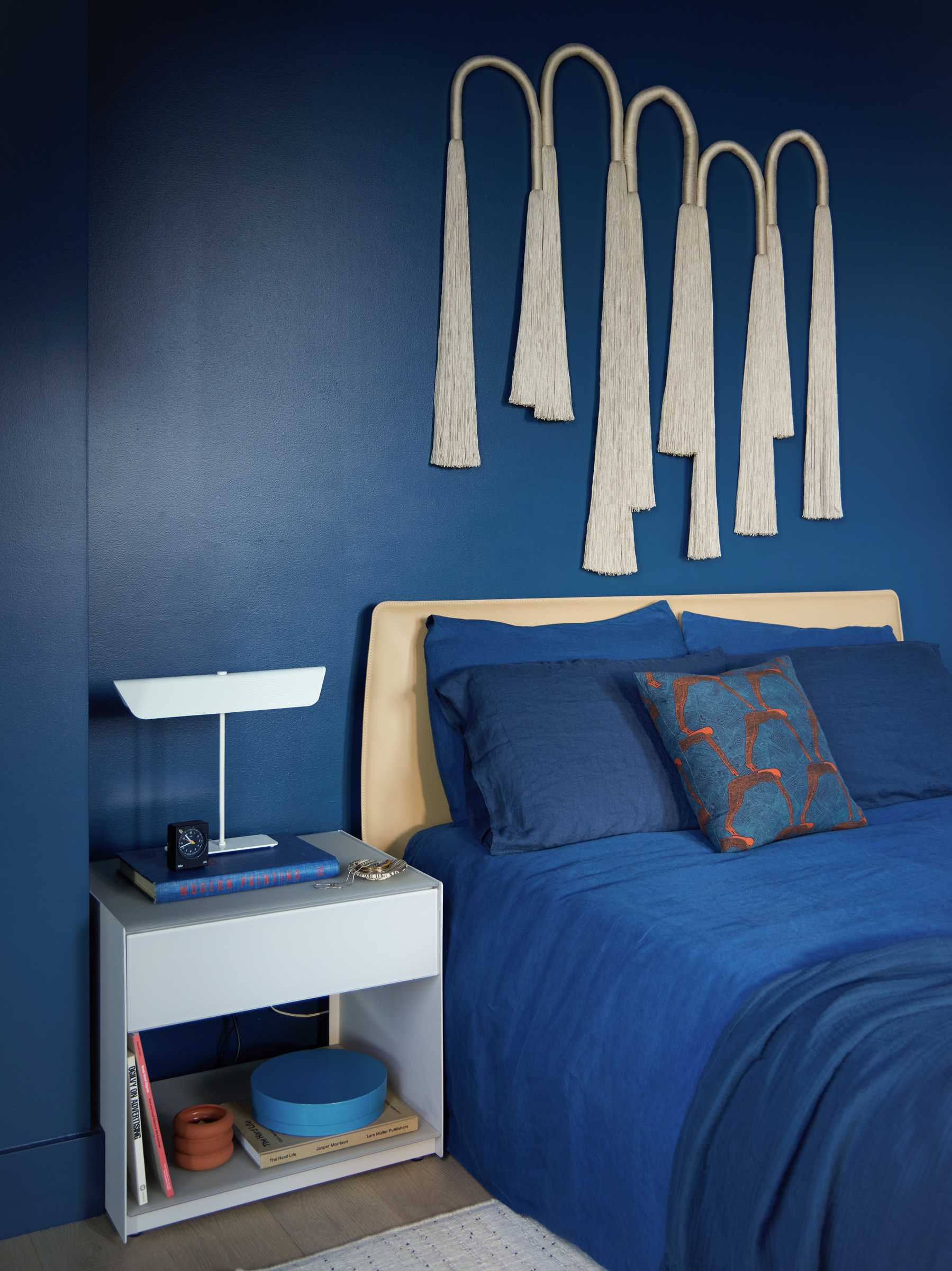 A modern bedroom with a rich blue color palette.