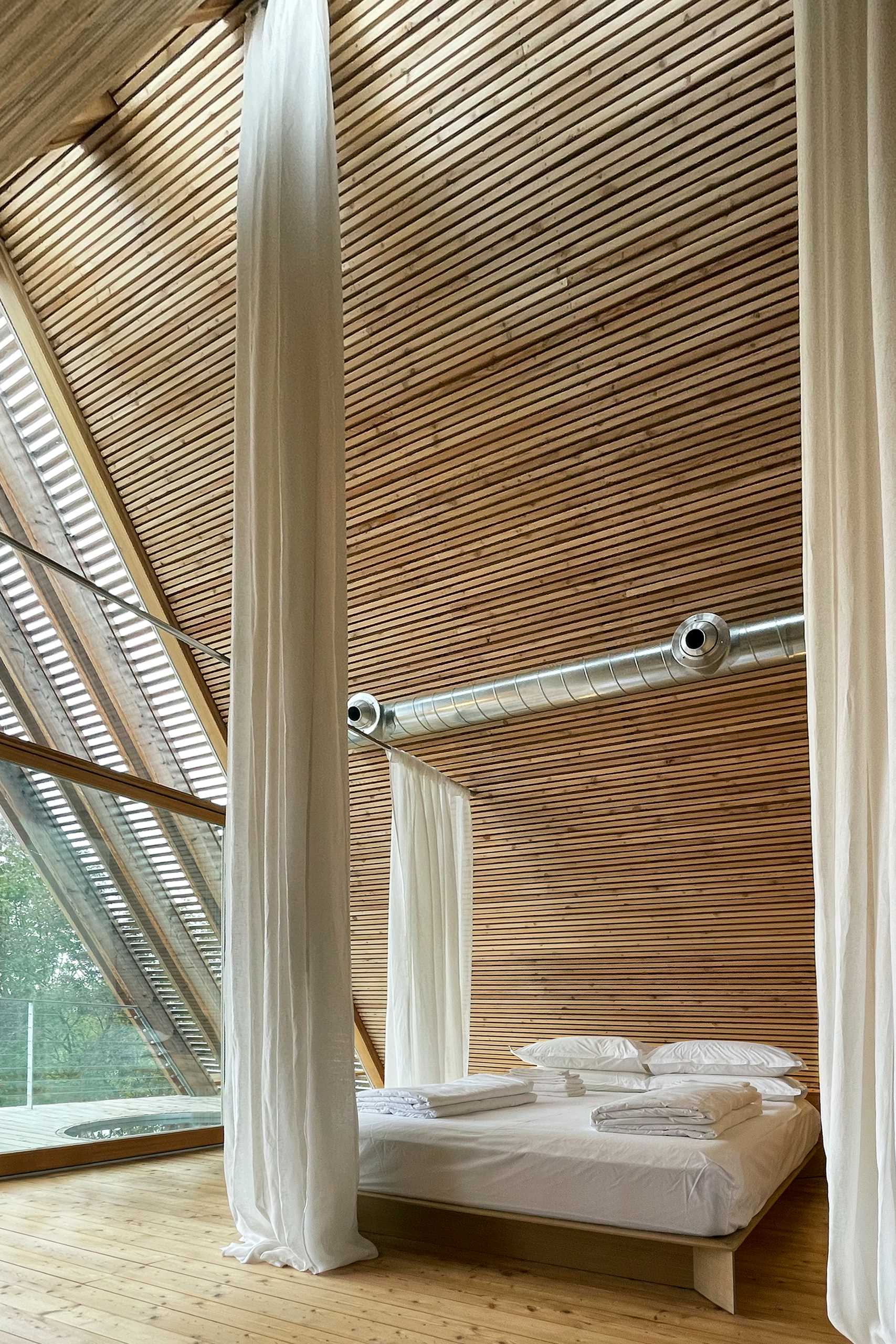 Long curtains hang from the ceiling and provide privacy for the sleeping area when closed.