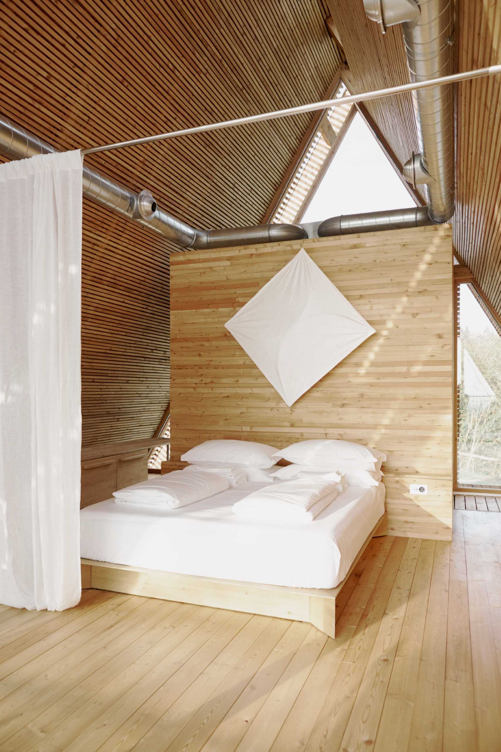Long curtains hang from the ceiling and provide privacy for the sleeping area when closed.