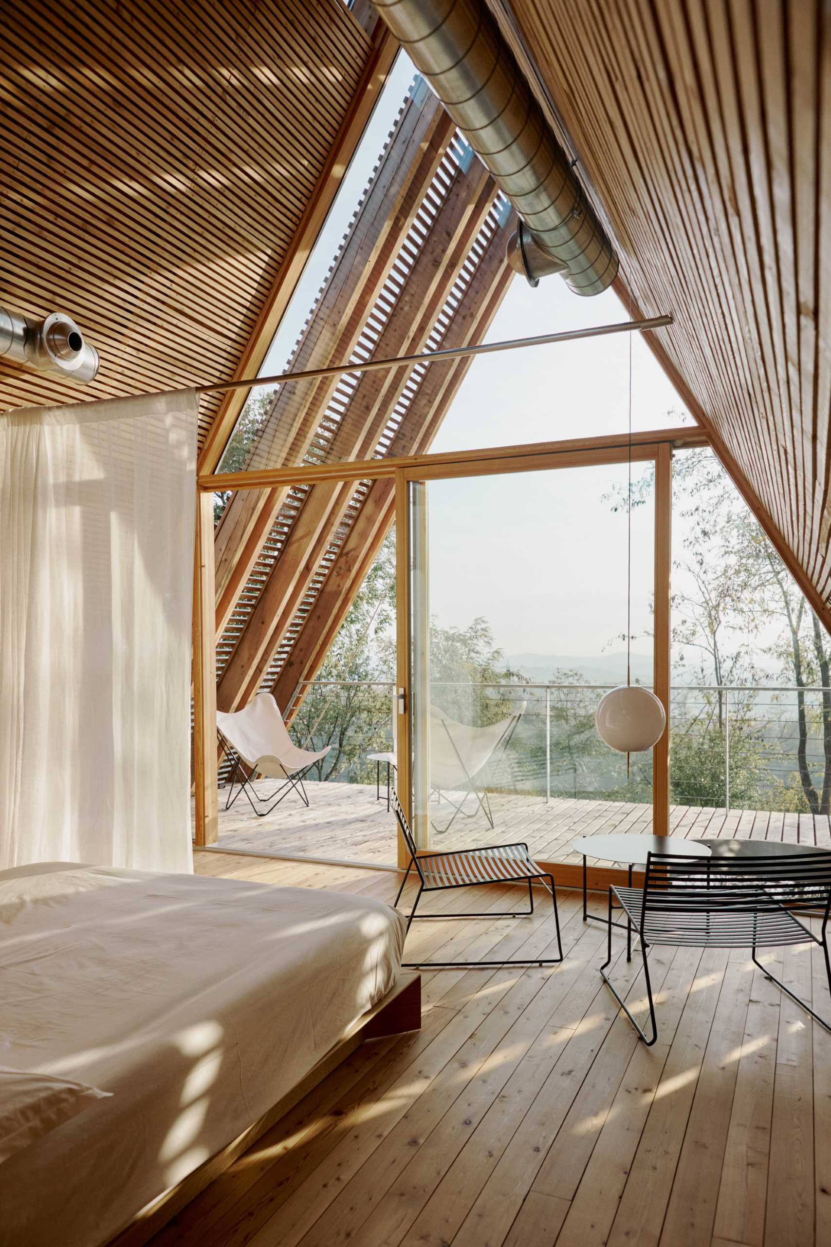Long curtains hang from the ceiling and provide privacy for the sleeping area when closed.