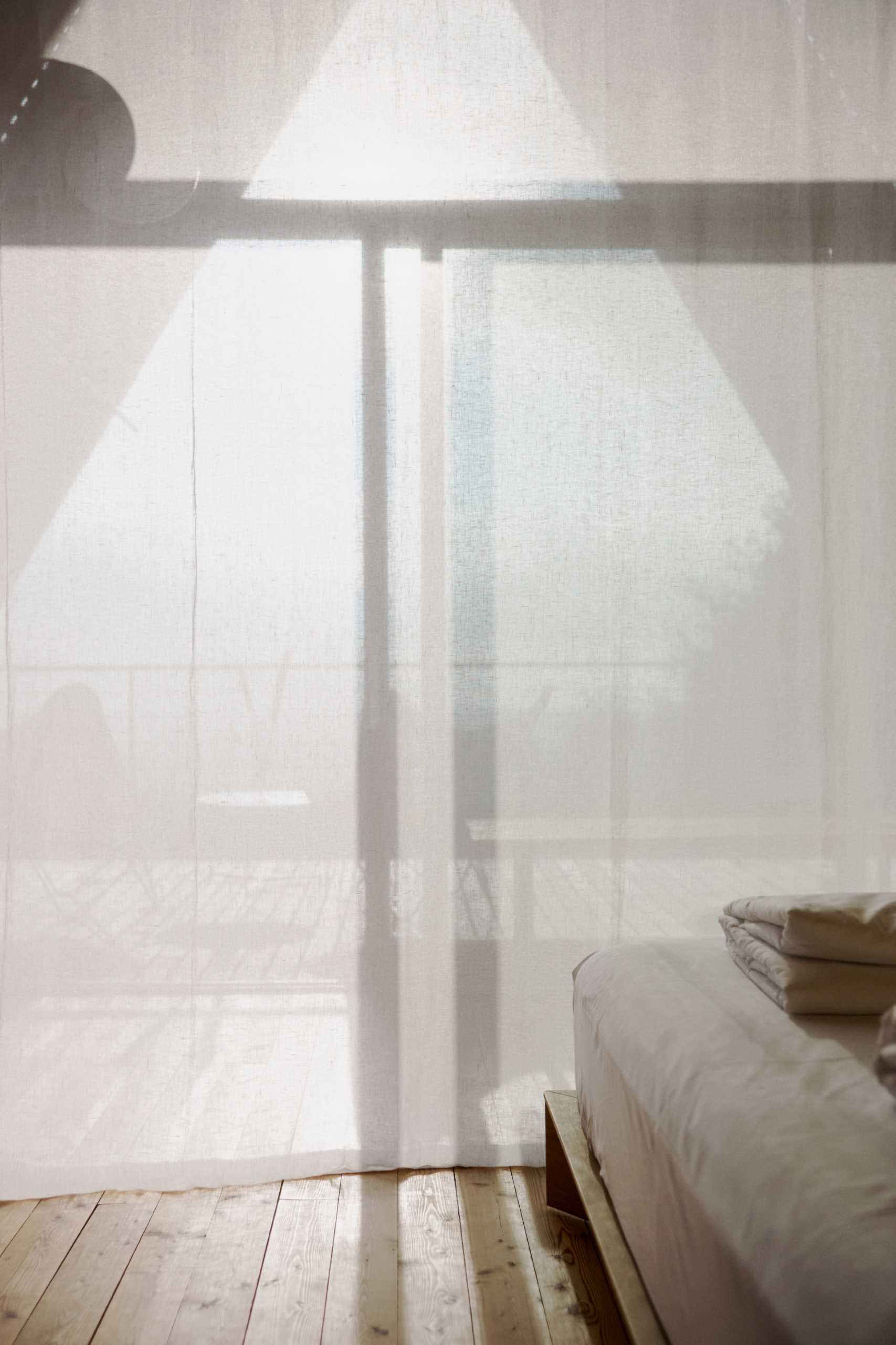 Long curtains hang from the ceiling and provide privacy for the sleeping area when closed.