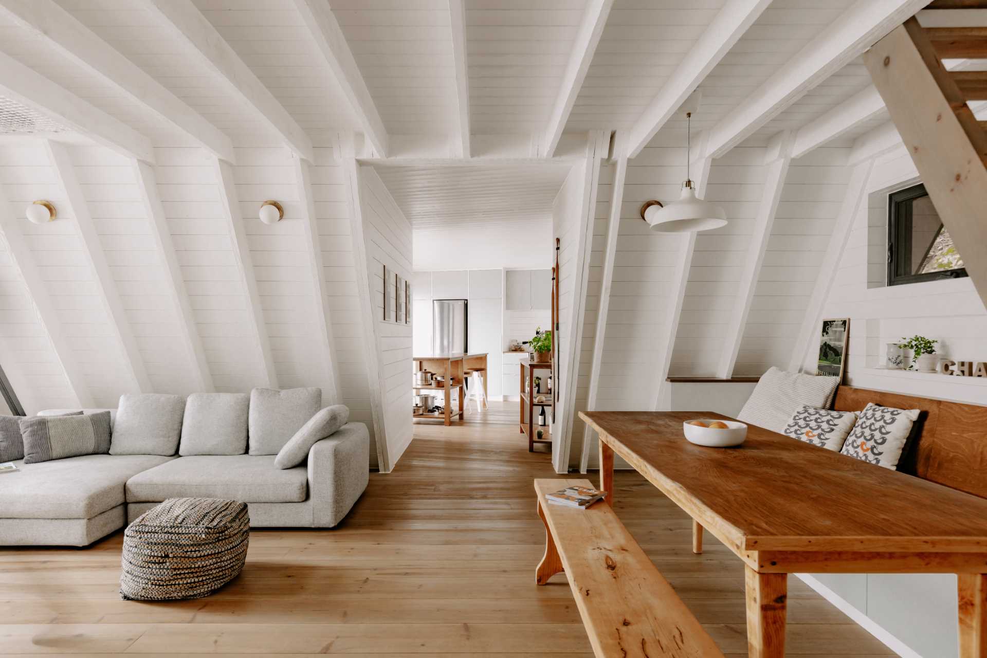 A updated A-Frame cabin with a white interior and wood floors.