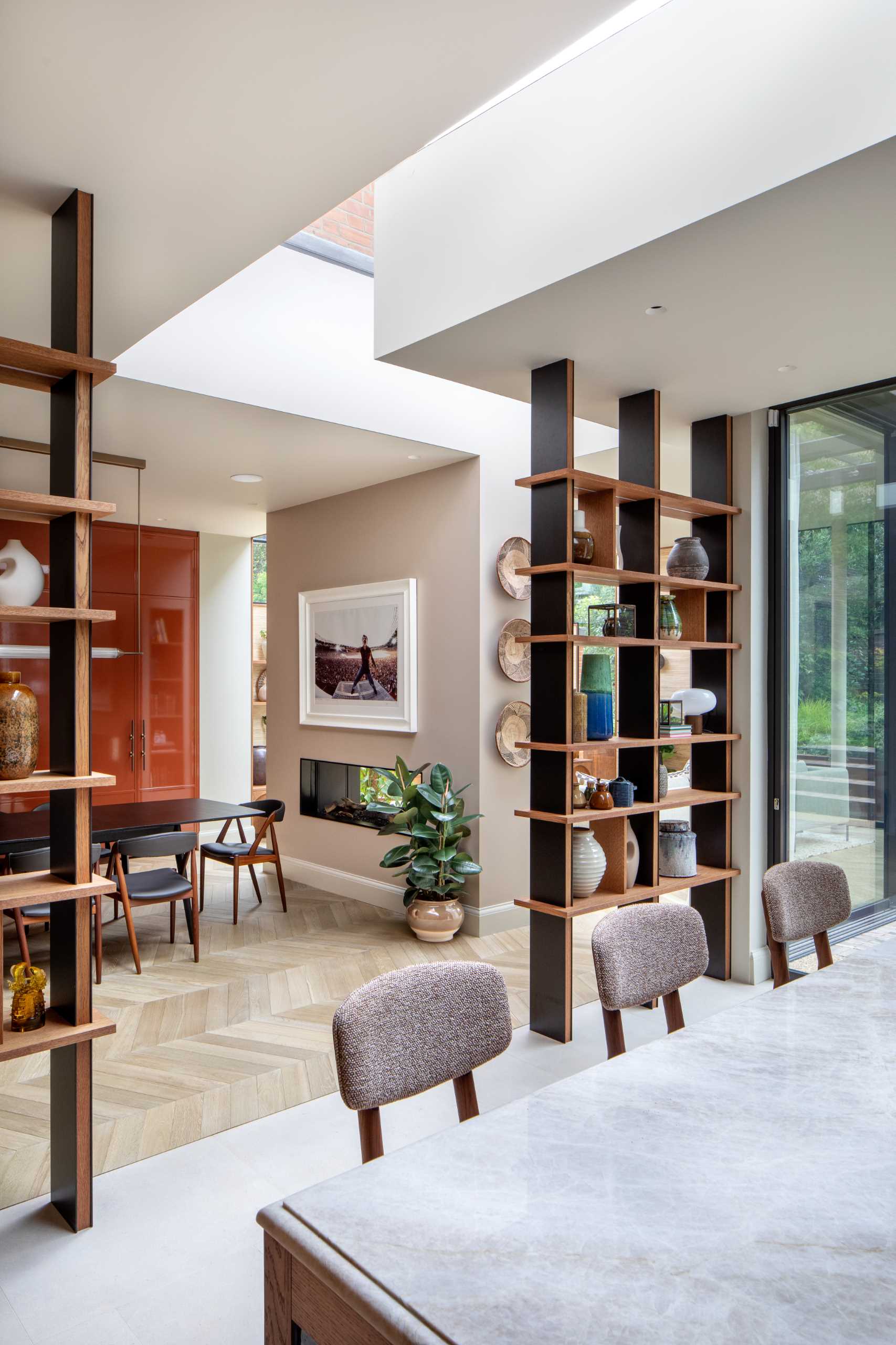 This dining room has views of the kitchen, while floor-to-ceiling bookshelves create an entryway for the kitchen.