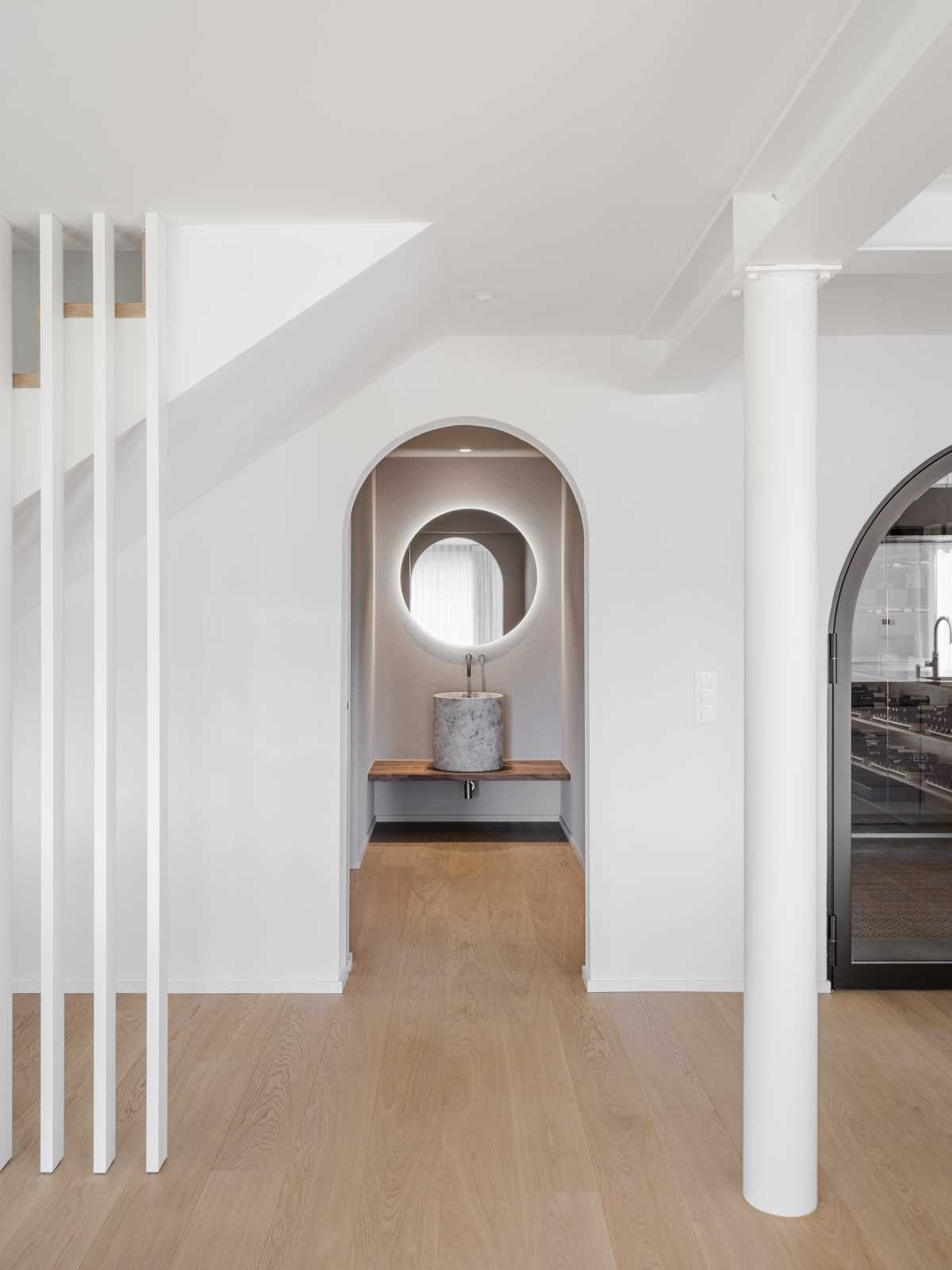 An arched doorway provides access to a hidden mirror and sink.