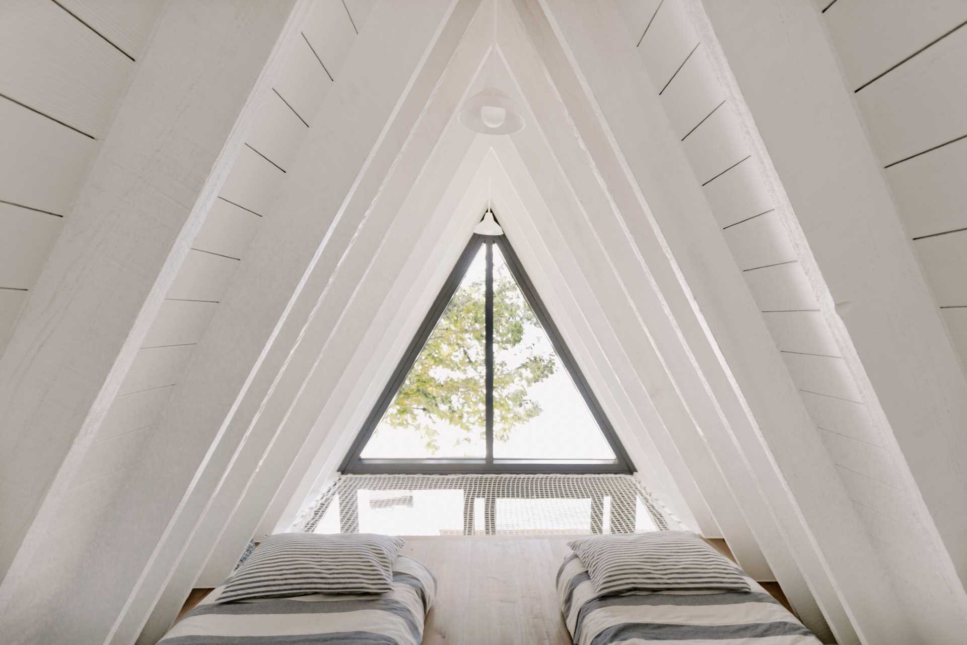Loft bedroom inside an A-frame cabin.