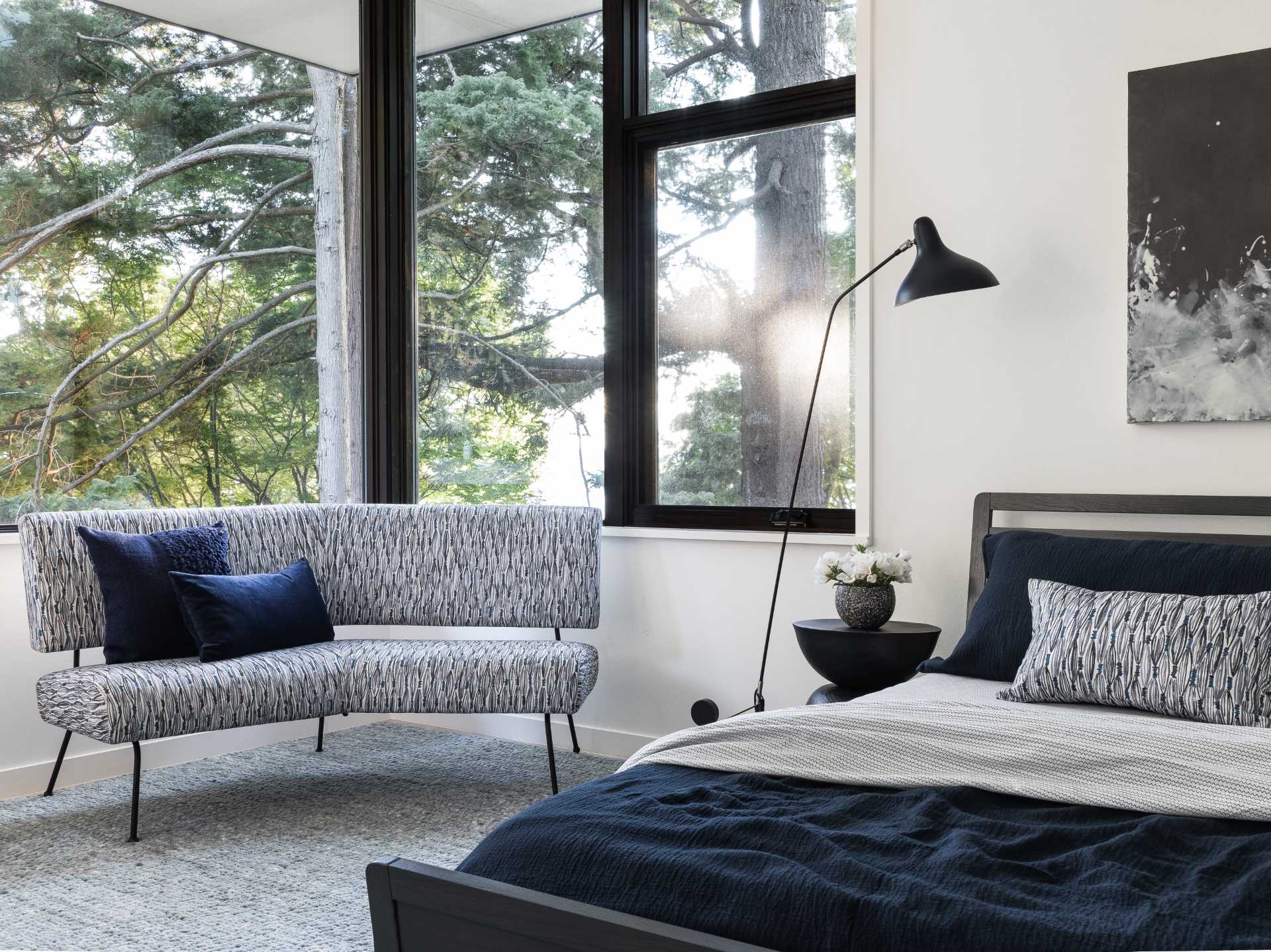 A modern black and grey bedroom with blue accents.
