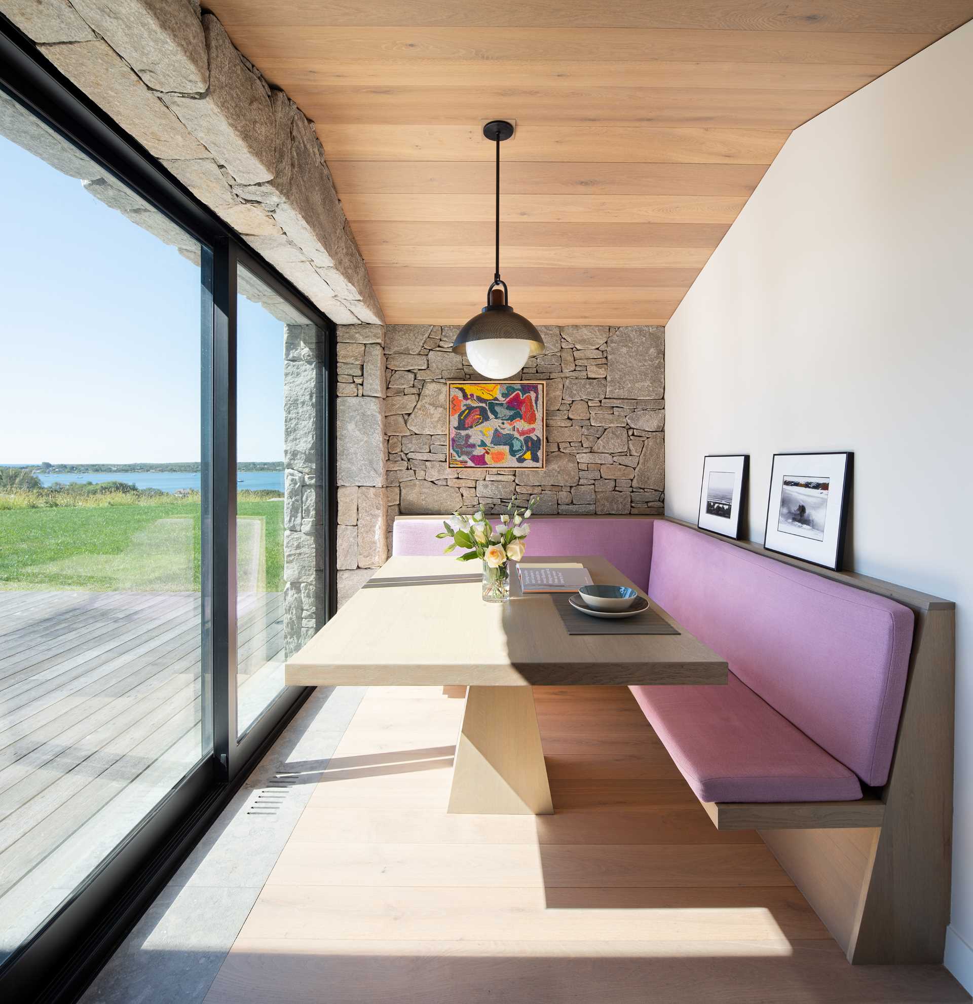 A small dining room with banquette seating and views of the outdoors.