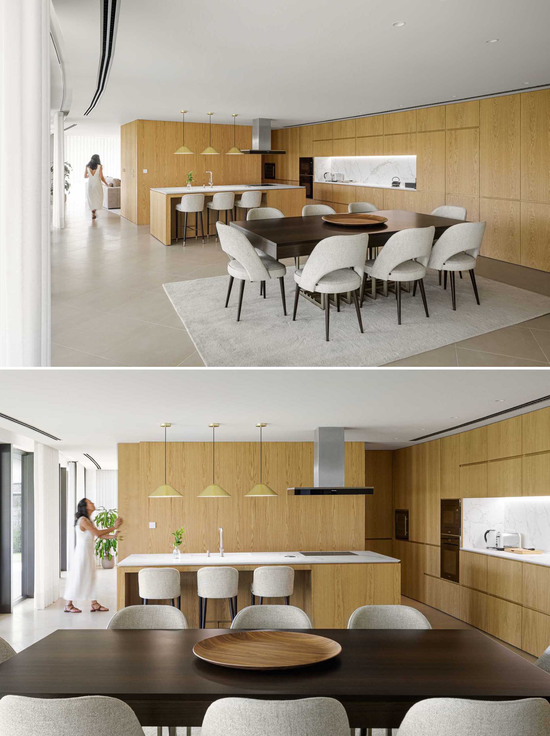 Warm wood walls and cabinets, and concrete floors connect the living room with the kitchen and dining area. The cabinetry that lines the wall also follows the curvature of the home.