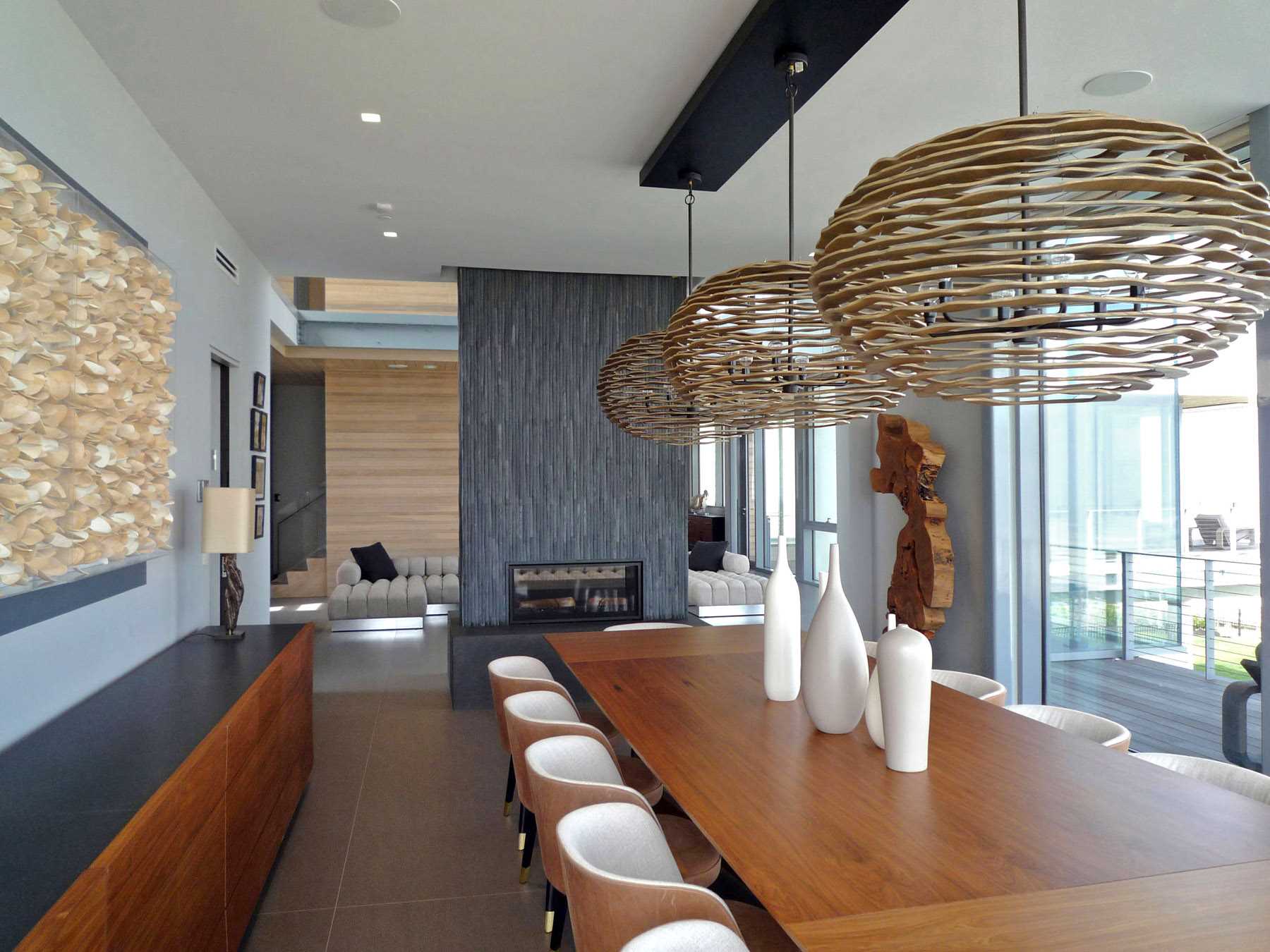 یک اتاق غذاخوری مدرن با شومینه و میز چوبی بزرگ.