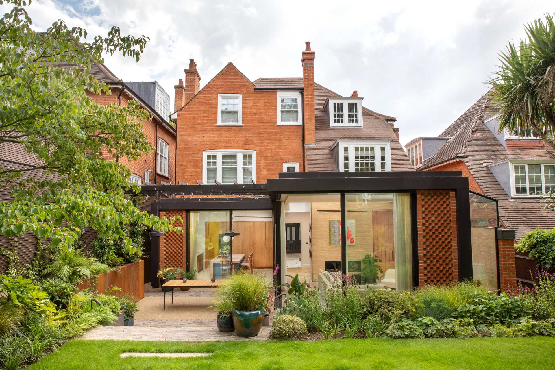 The architects removed the existing conservatory of this home and added a new rear extension with an integrated strip of glass, that separates the original building from the contemporary extension.