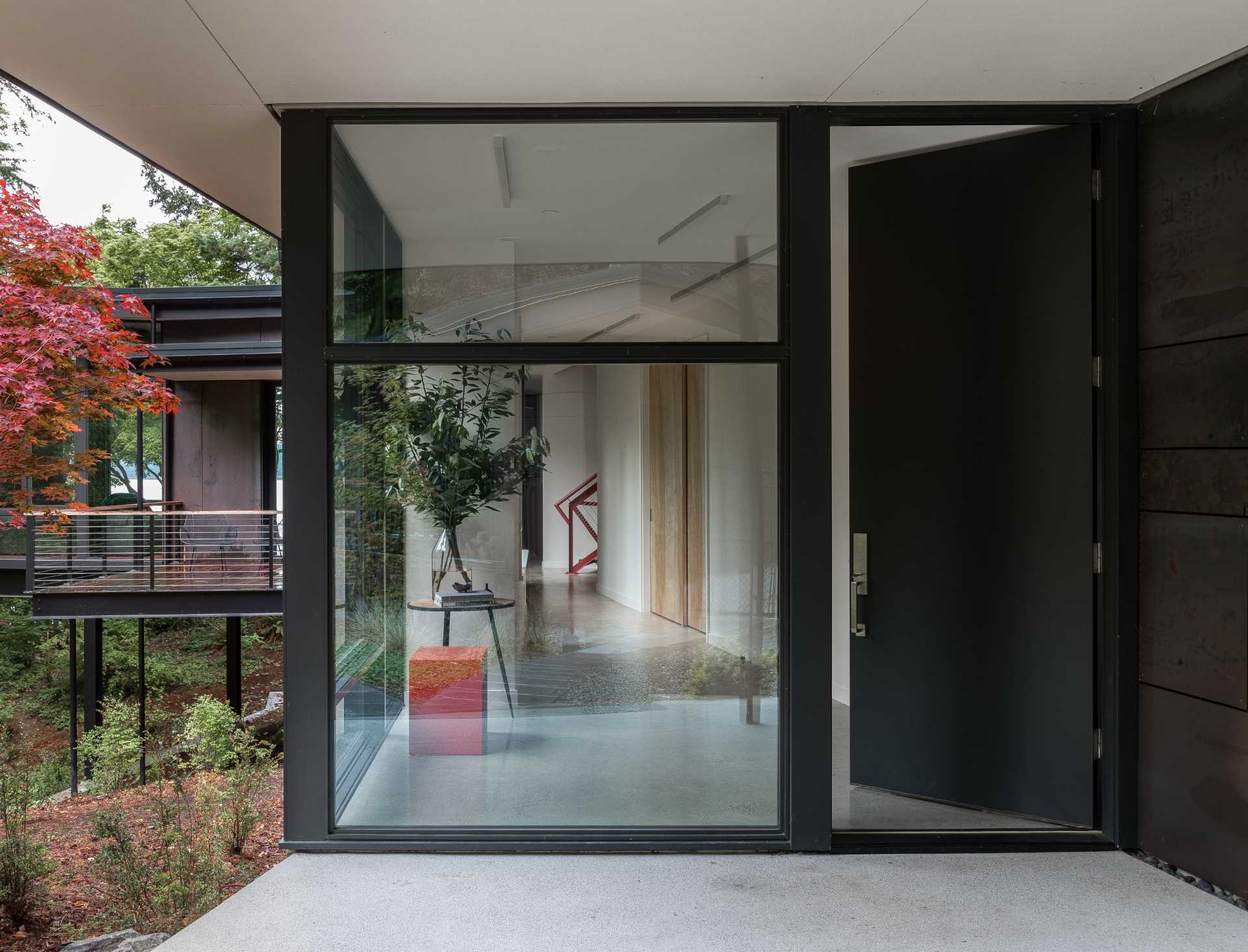 A modern home with a black front door that matches the black window frames.