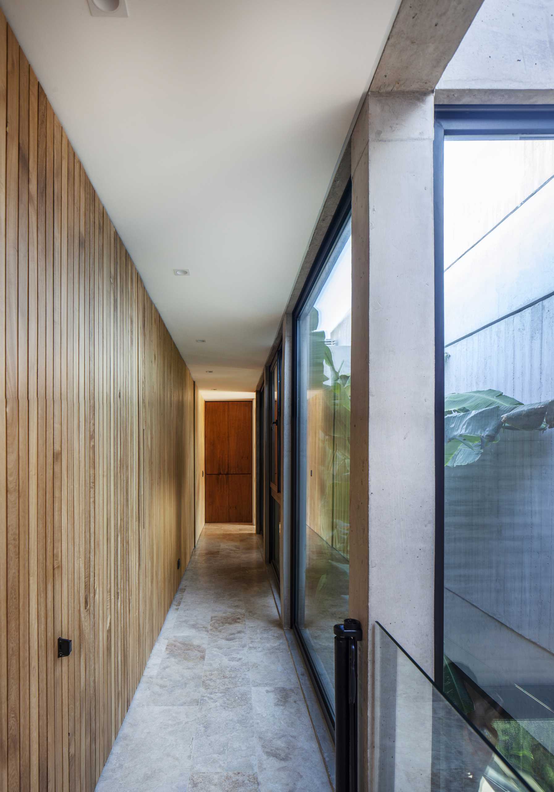 A modern home with a hallway lined with wood.