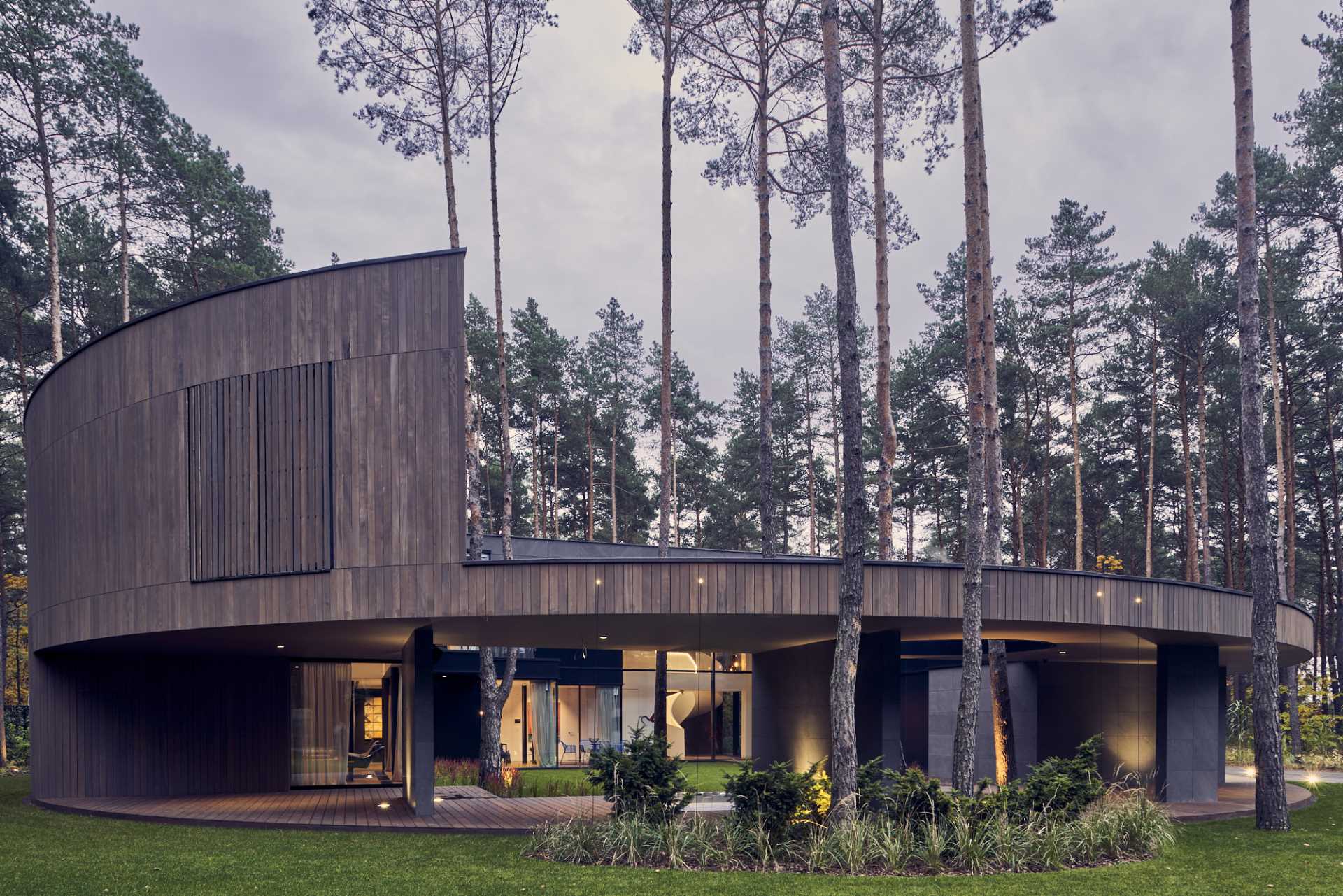 A modern home with a round design, and clad with Okume wood.