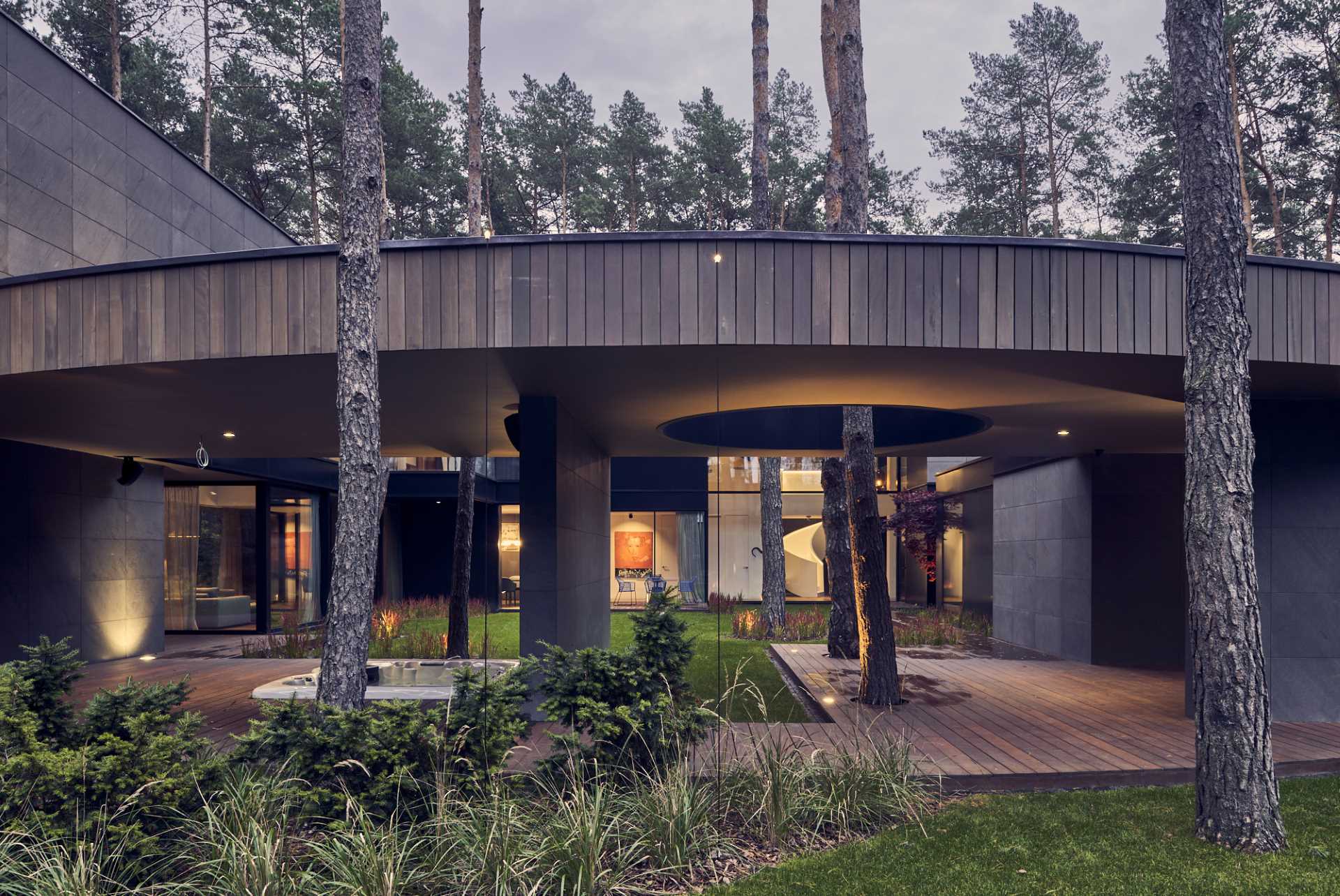 A modern home with a round design, and clad with Okume wood.