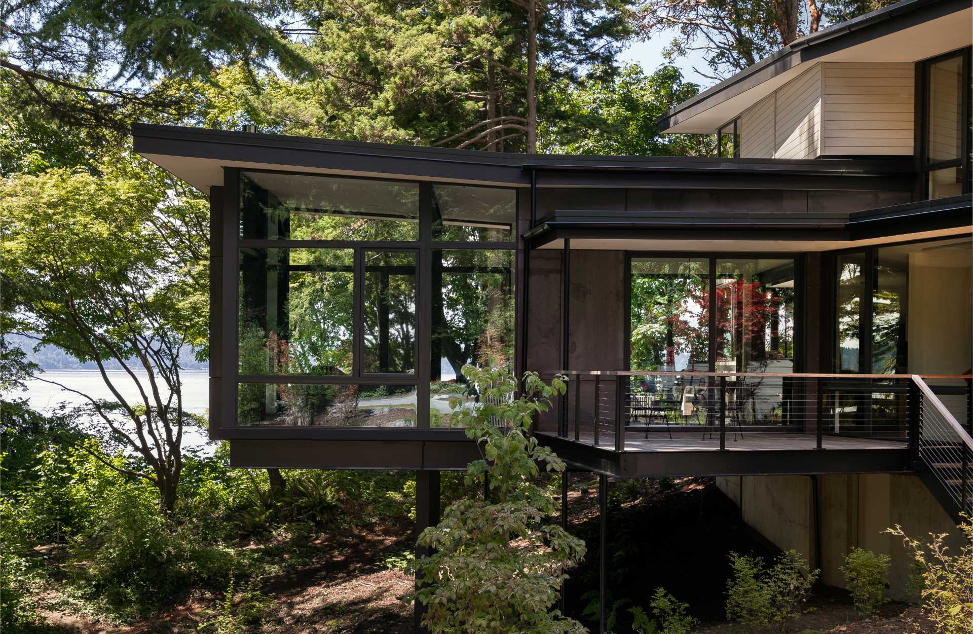 A modern home in the trees with a living room suspended above the forest floor.