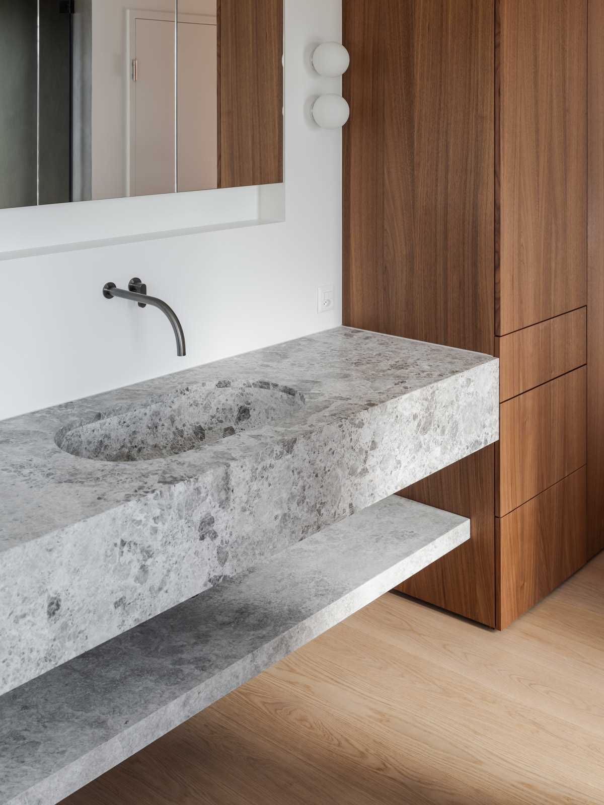 A modern stone vanity with wood cabinets.