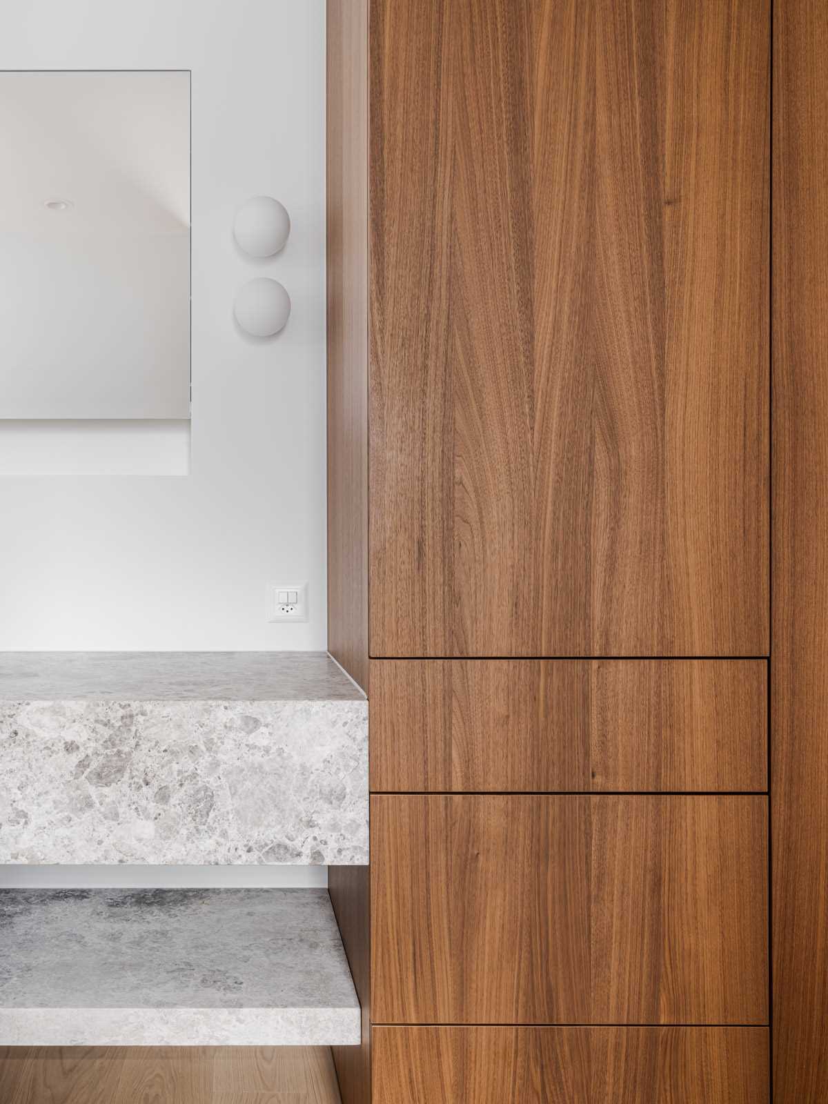 A modern stone vanity with wood cabinets.