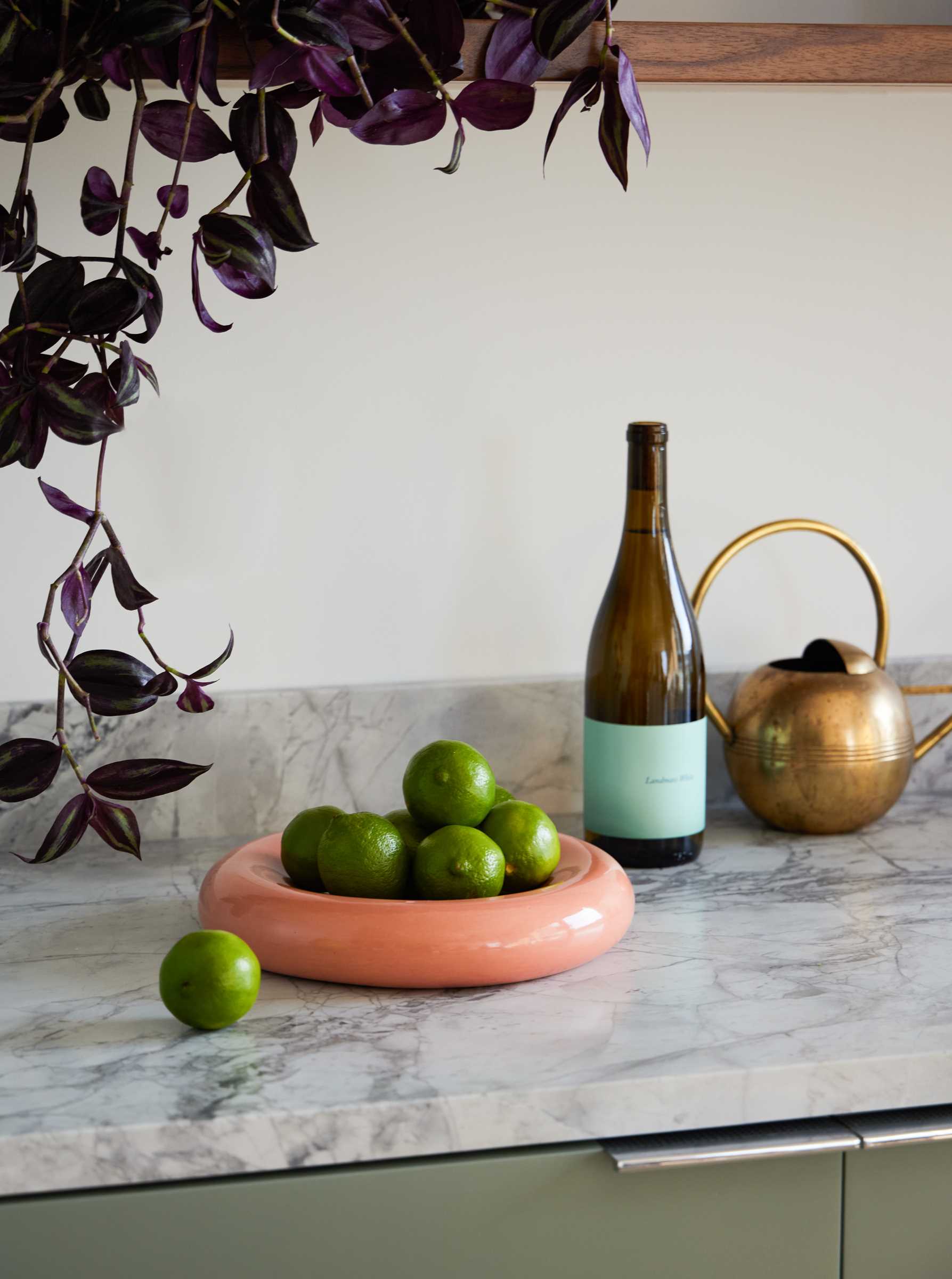 A modern kitchen with pale matte green cabinets and Dolomite countertop.