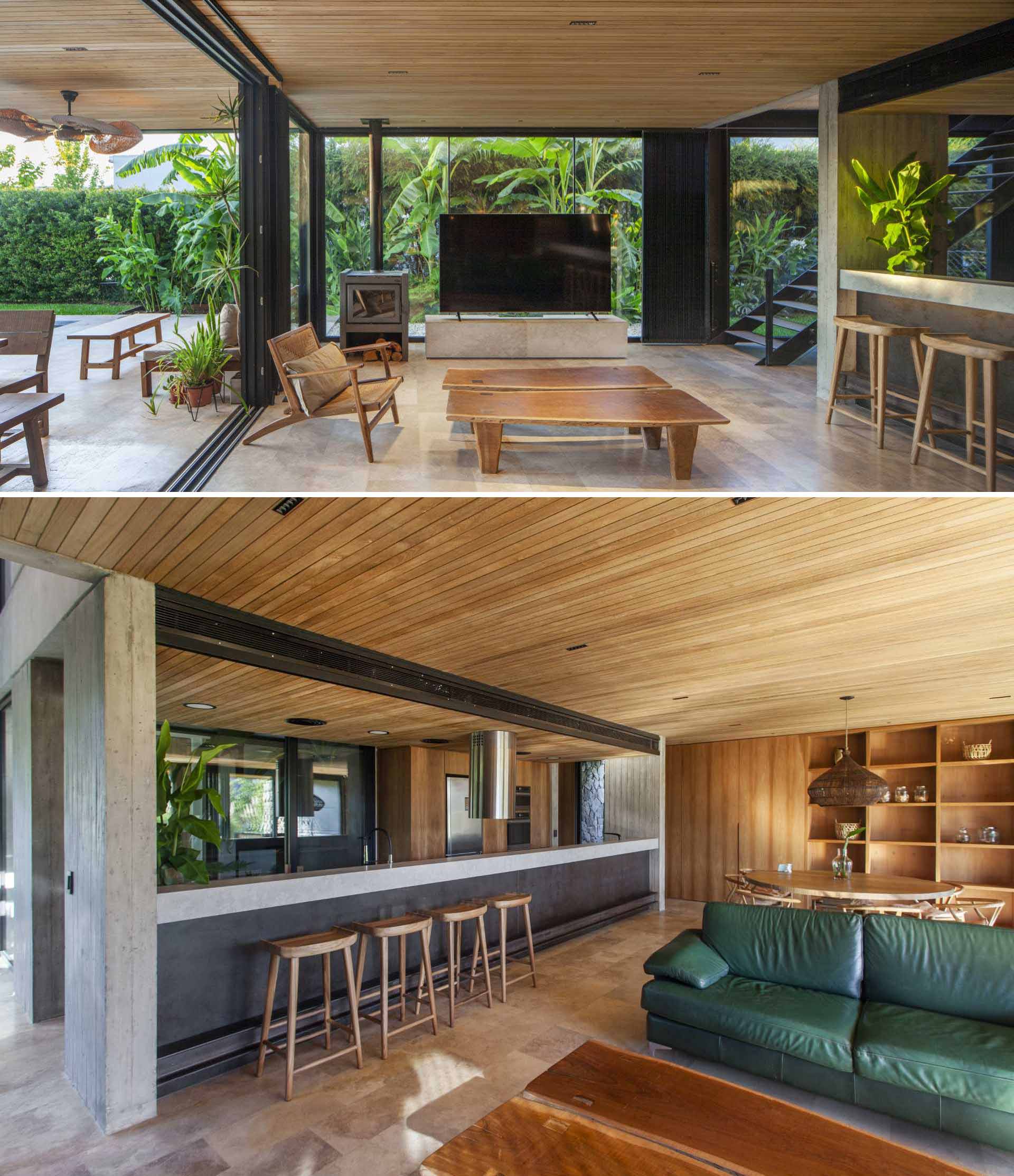 This modern living room has floor-to-ceiling windows that act as a backdrop for the television and fireplace.