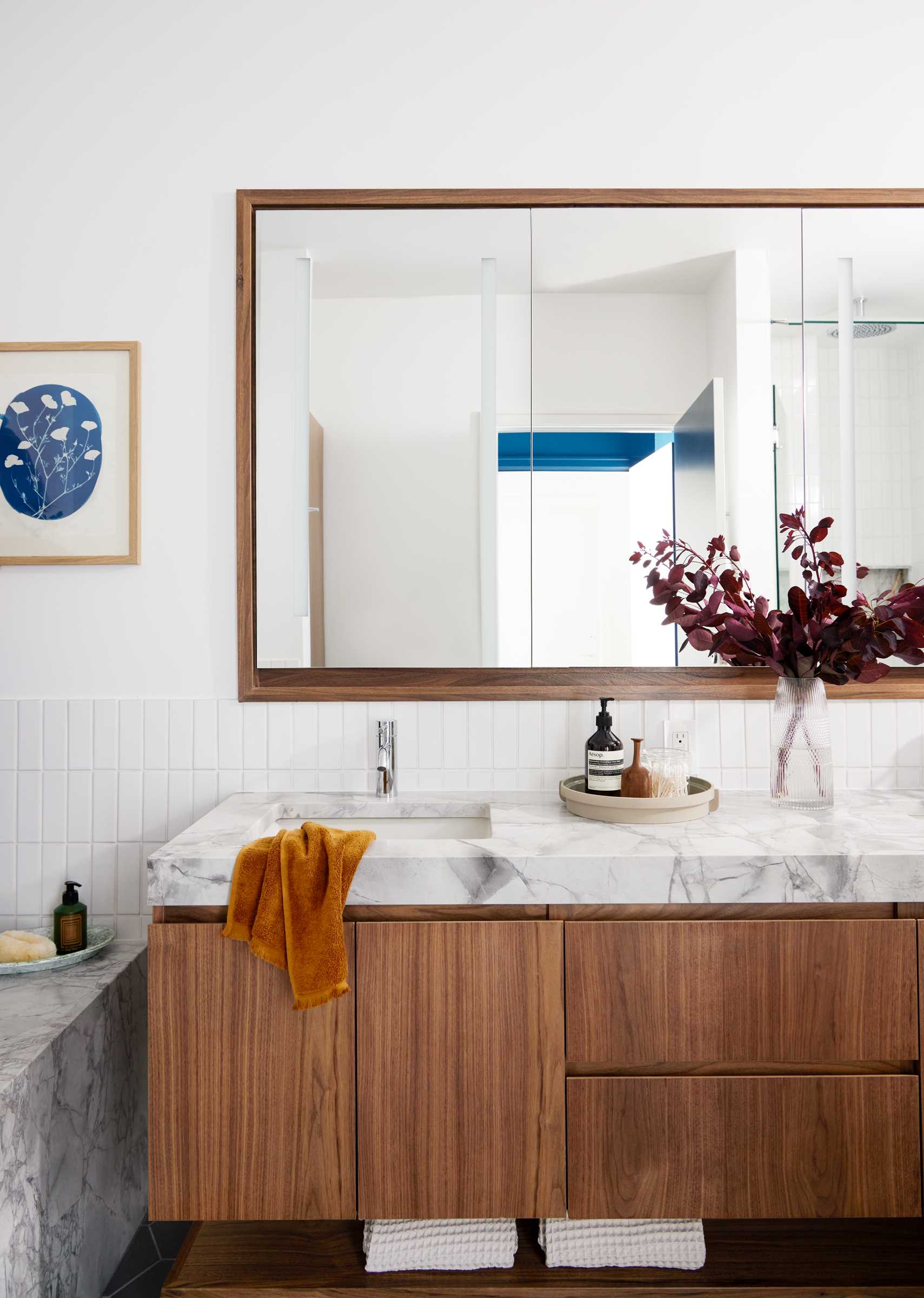 The updated primary bathroom includes Dolomite countertop and bathtub surround, while a new wood vanity increases storage, and vertical subway tiles line the walls.