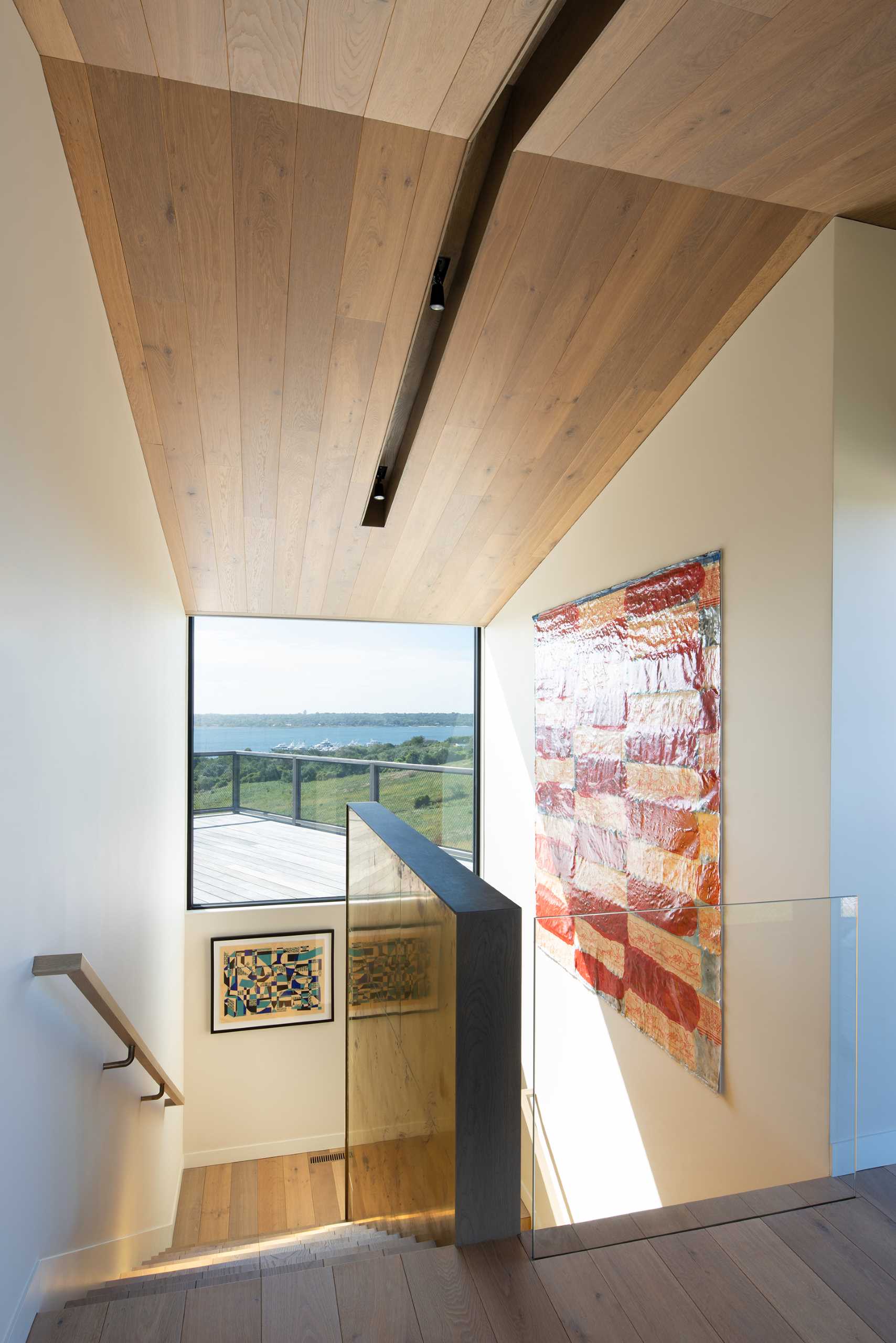 A modern home with a staircase that includes a large picture window.