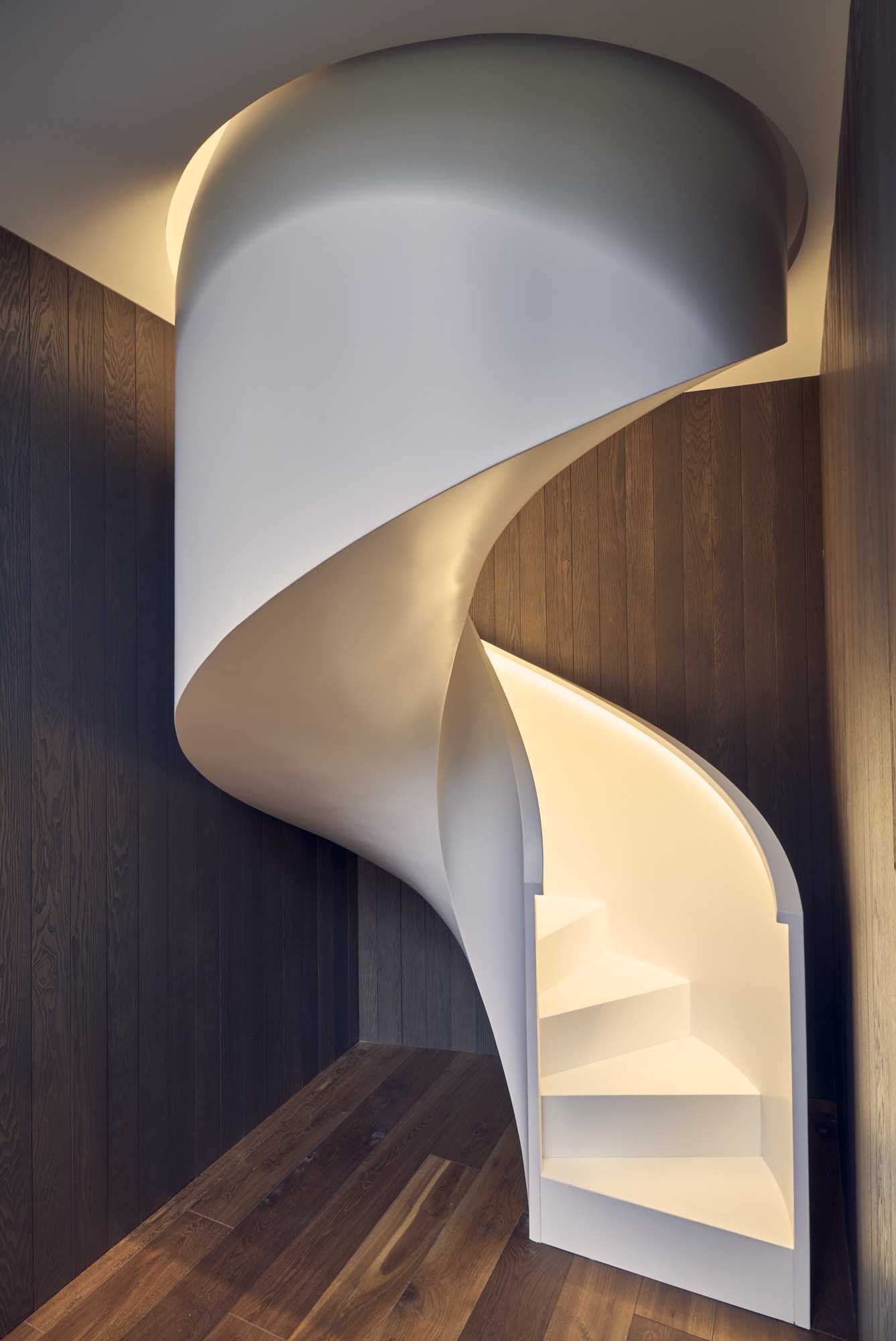 Sculptural white spiral staircase with hidden lighting.
